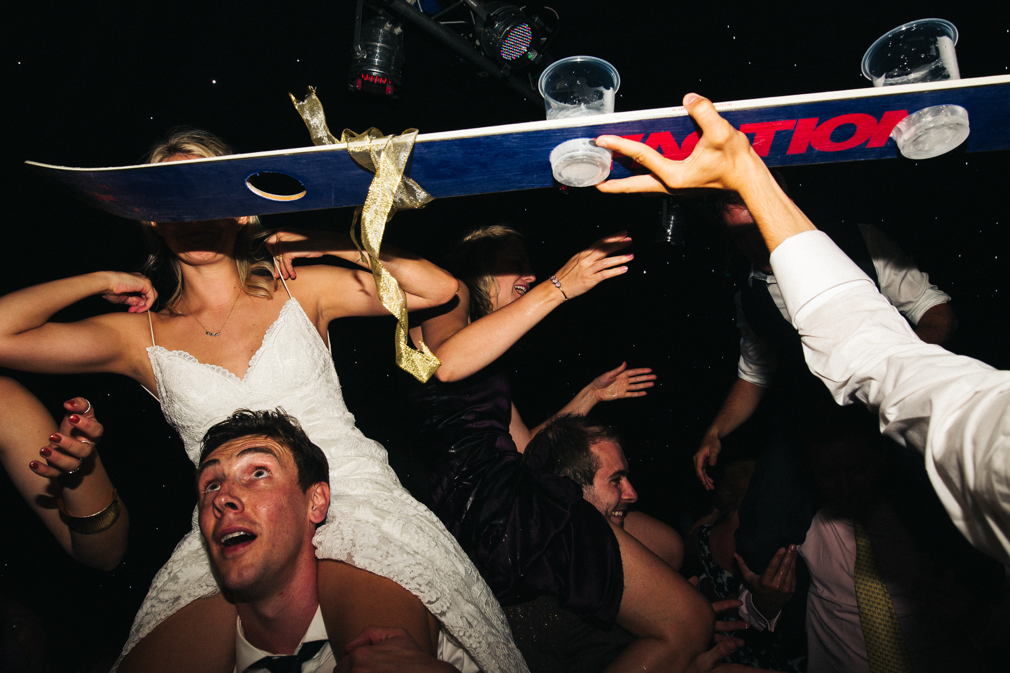 a busy dancefloor shot with a bride on the shoulders of a guest. marquee wedding in stirling in scotland. stop motion wedding films videos uk