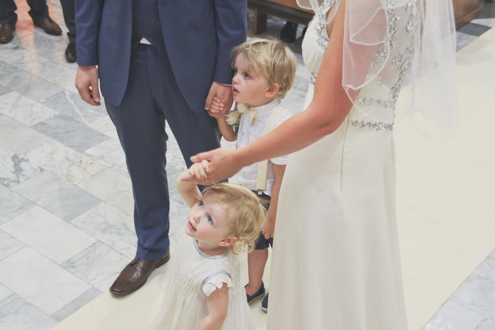 a boy and girl stand with their parents as they get married. destination wedding photography in italy, rome. stop motion wedding films