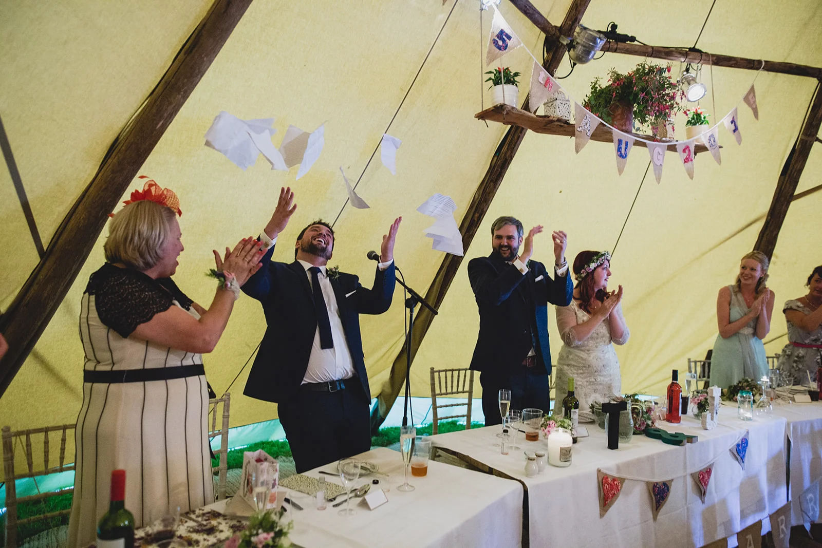a best man throws his notes in the air following his speech. camp katur wedding north yorkshire tipi wedding venue glamping. stop motion wedding films uk