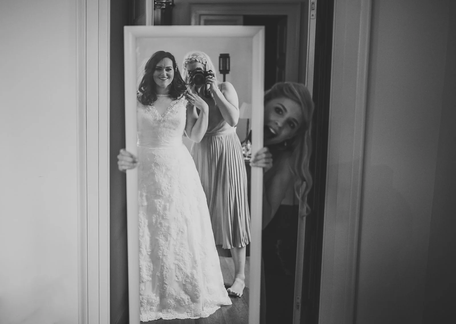 a bride and her bridesmaids look into the mirror at her reflection. destination creative wedding photography italy. stop motion wedding films uk