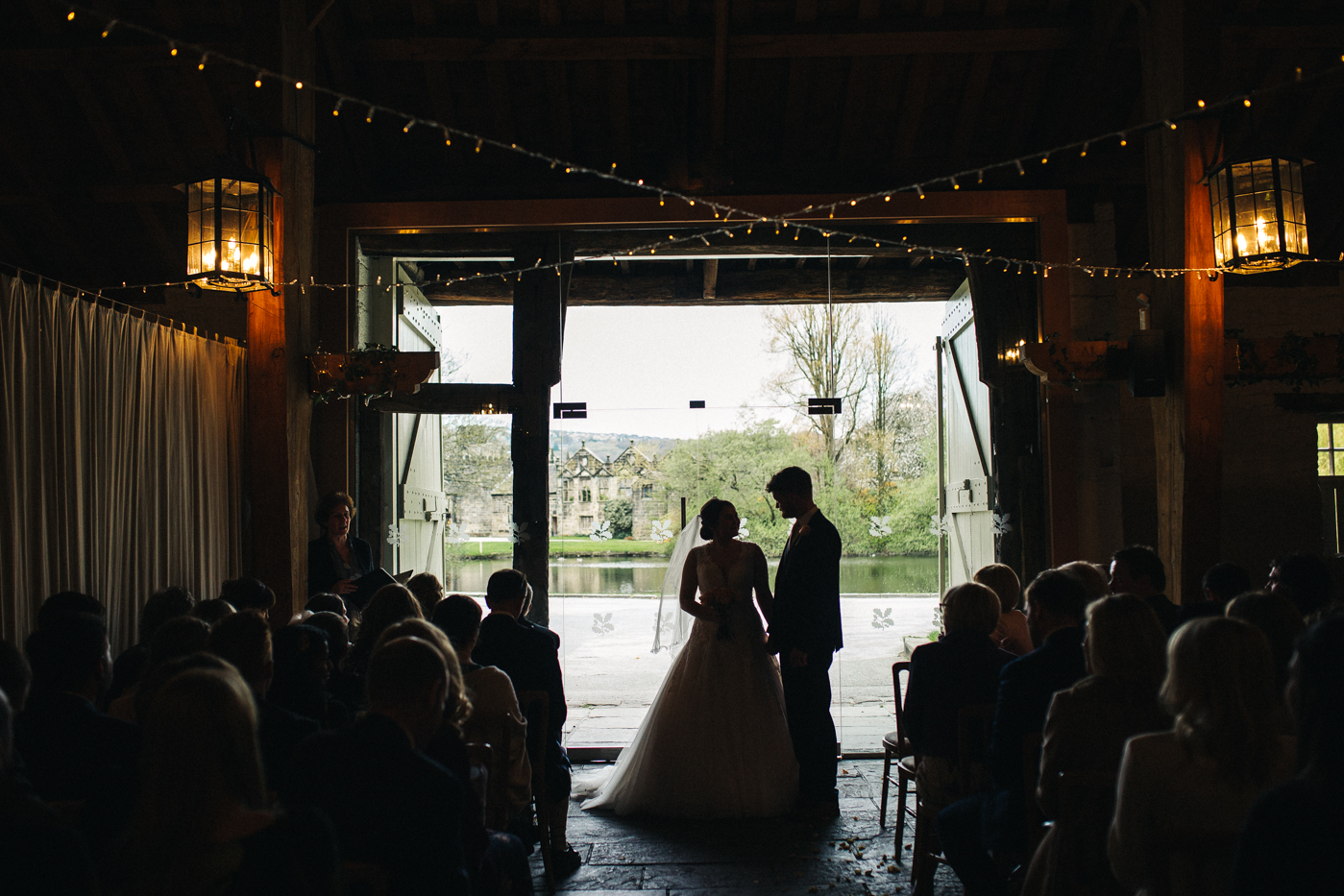 a wide shot of the bride and groom during the ceremony. spring barn wedding at east riddlesden hall keighley west yorkshire wedding photographer