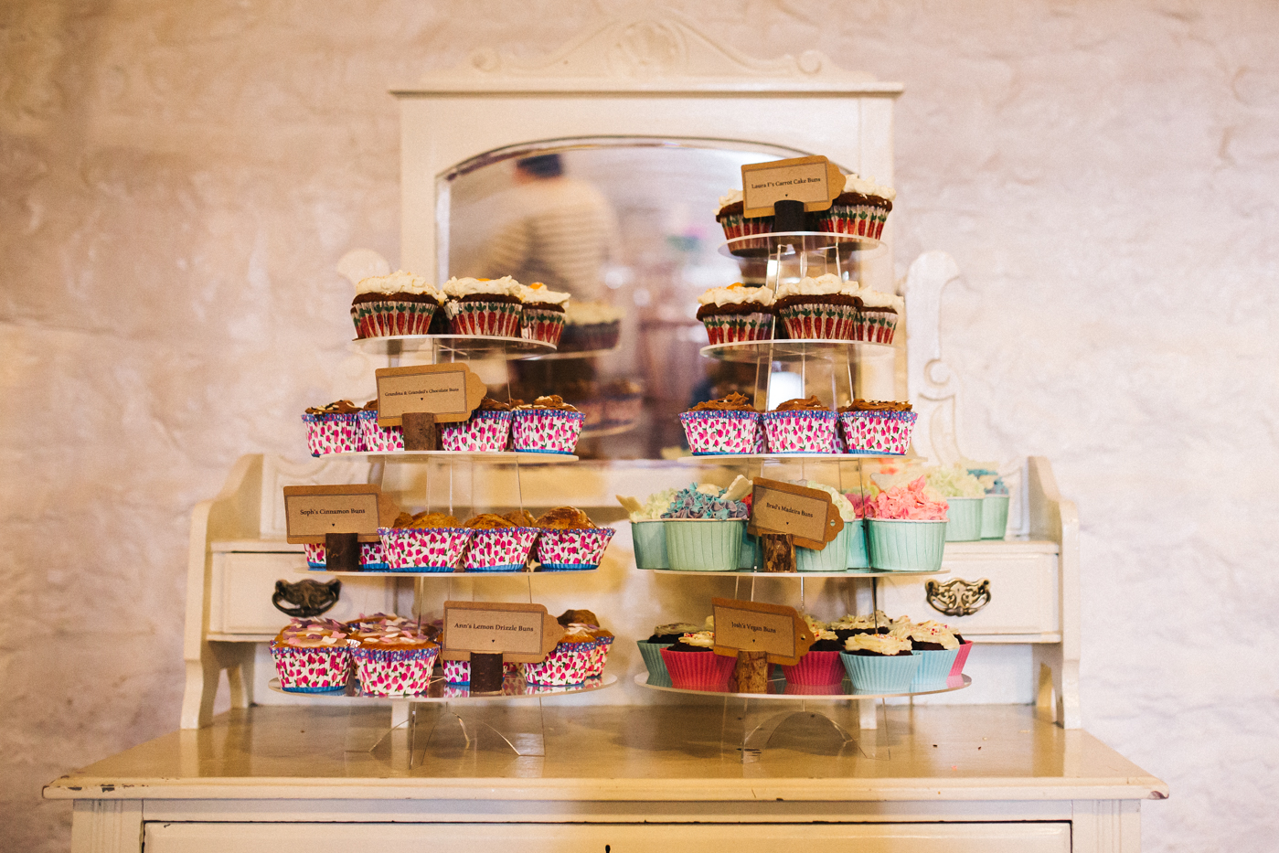 cupcakes piled high on a dresser at the wedding. spring barn wedding at east riddlesden hall keighley west yorkshire wedding photographer