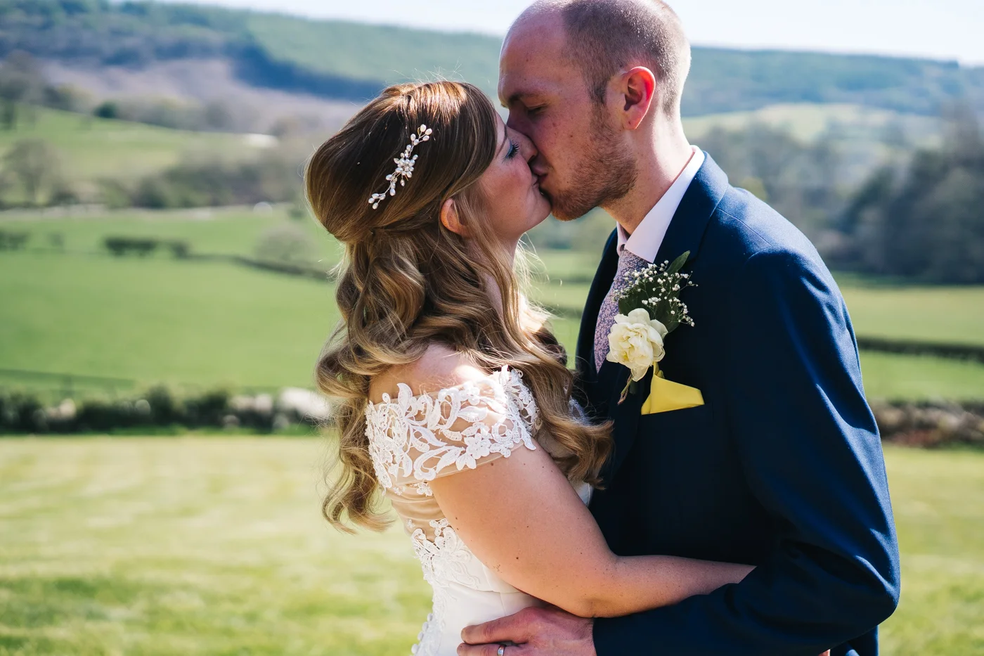 the couple kiss in front of a beautiful yorkshire view. wedding at laskill house north yorkshire helmsley wedding photographer north east teesside