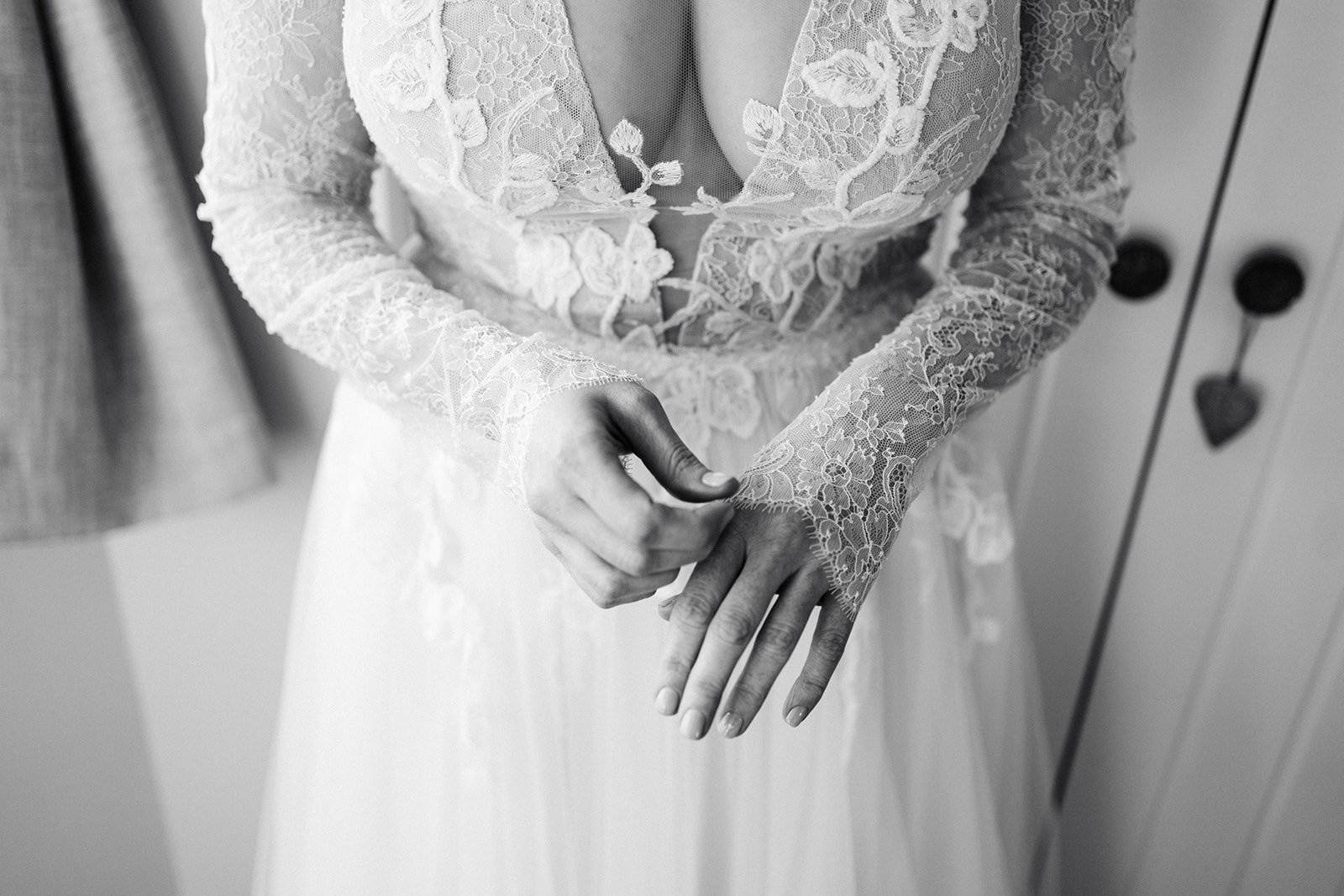 black and white image of a bride adjust8ing her lace wedding dress sleeves. the normans York wedding