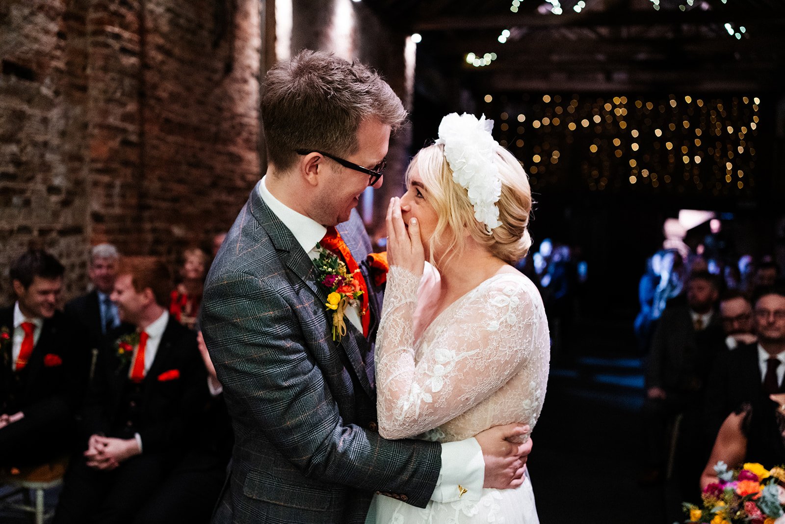 bride and groom during their barn wedding ceremony. They are close and the bride looks happy but overwhelmed. the normans York wedding