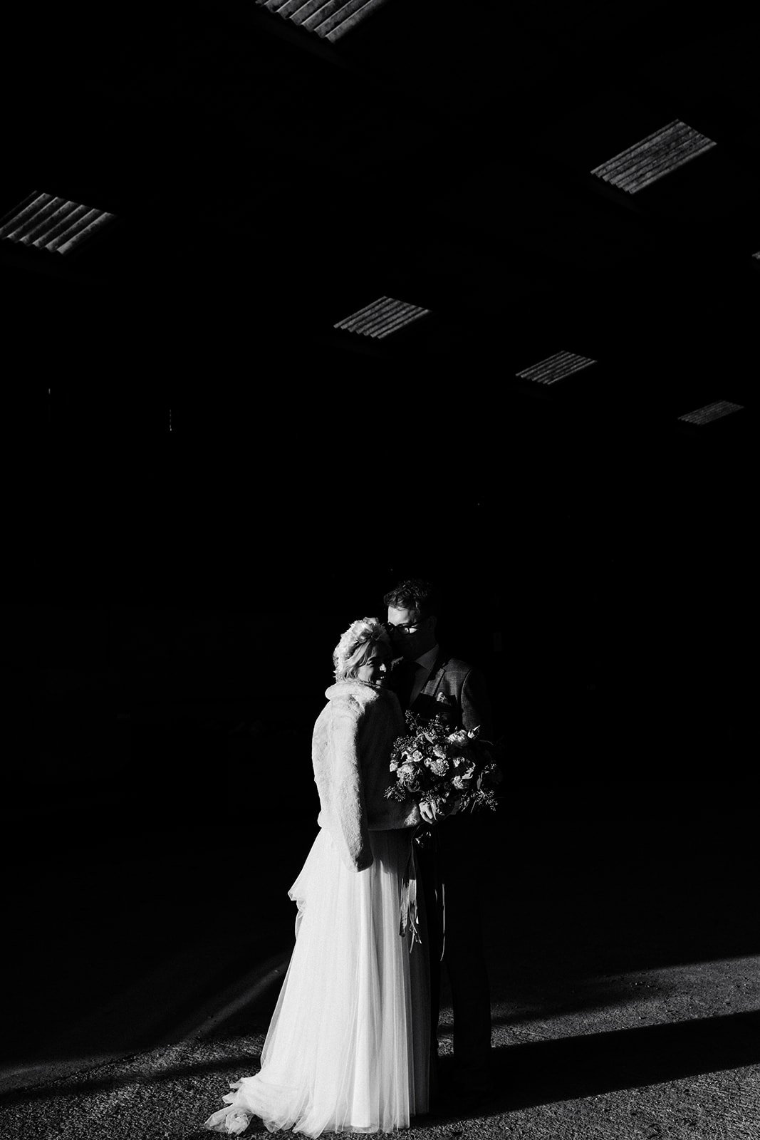 black and white portrait of a bride and groom standing in a barn wedding venue. the normans York wedding