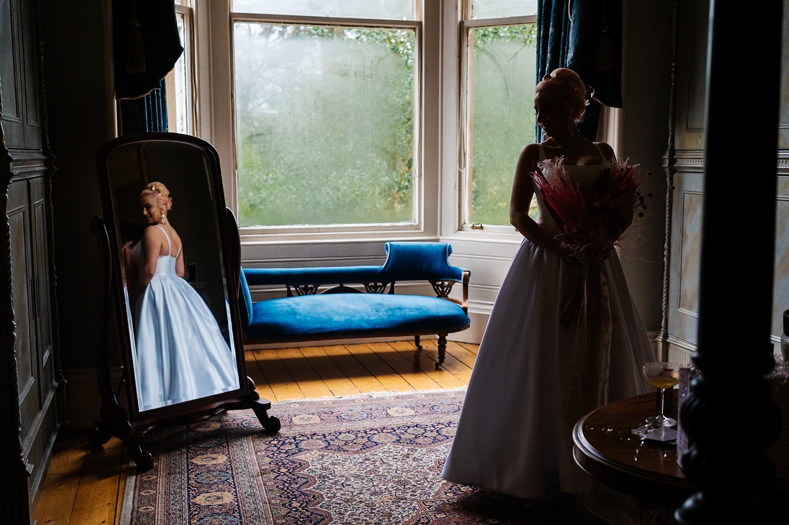 a bride looks back at her own reflection in a dressing room. wedding at toftcombs in Scotland