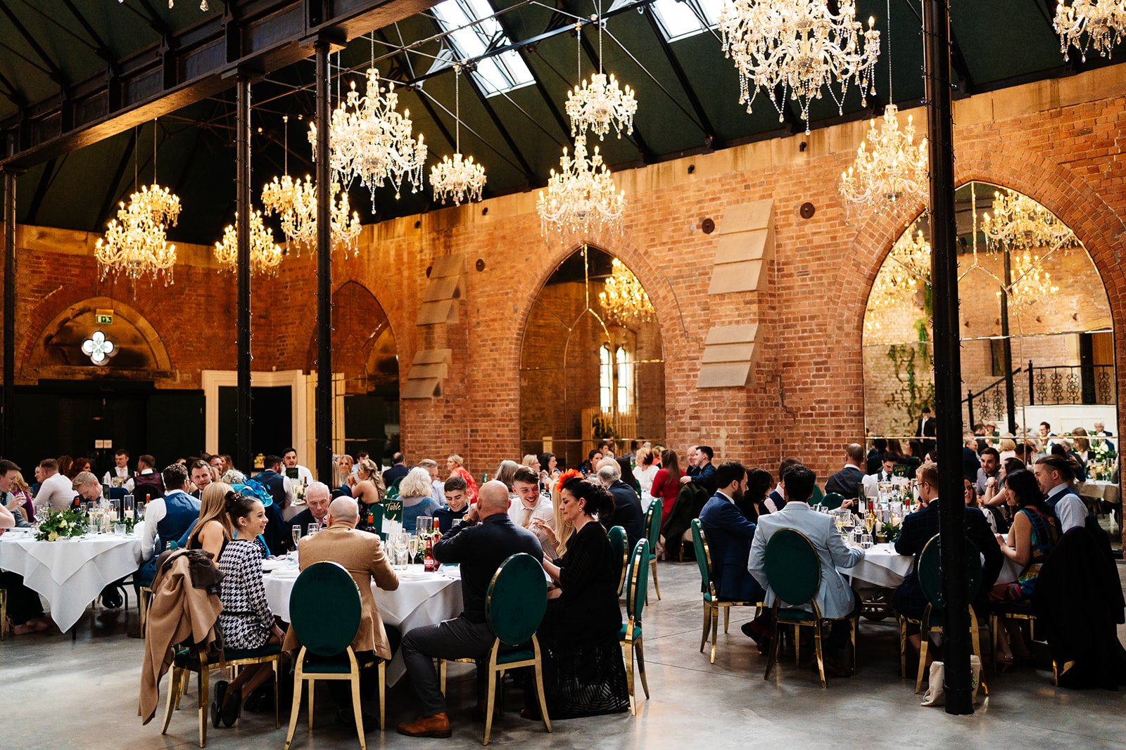 an industrial ceremony room filled with guests during the wedding meal at the dalton old pump house