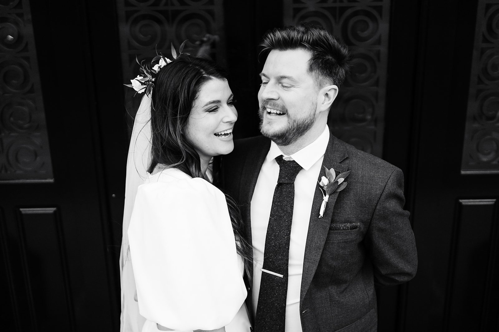 black and white photo of a bride and groom laughing and facing each other. wedding at dalton old pump house 