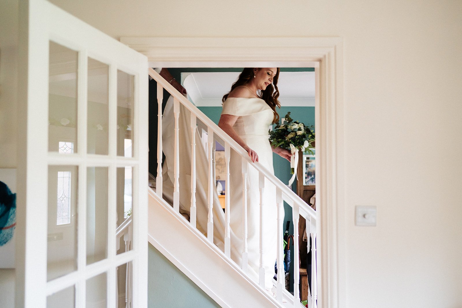 A bride walks down the stairs at her parents house looking ahead ahead of her wedding at Wylam Brewery in Newcastle
