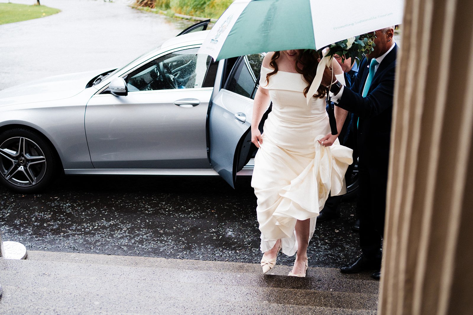 A bride walks under an umbrella up the steps at Wylam Brewery in Newcastle. Her face is partly obscured