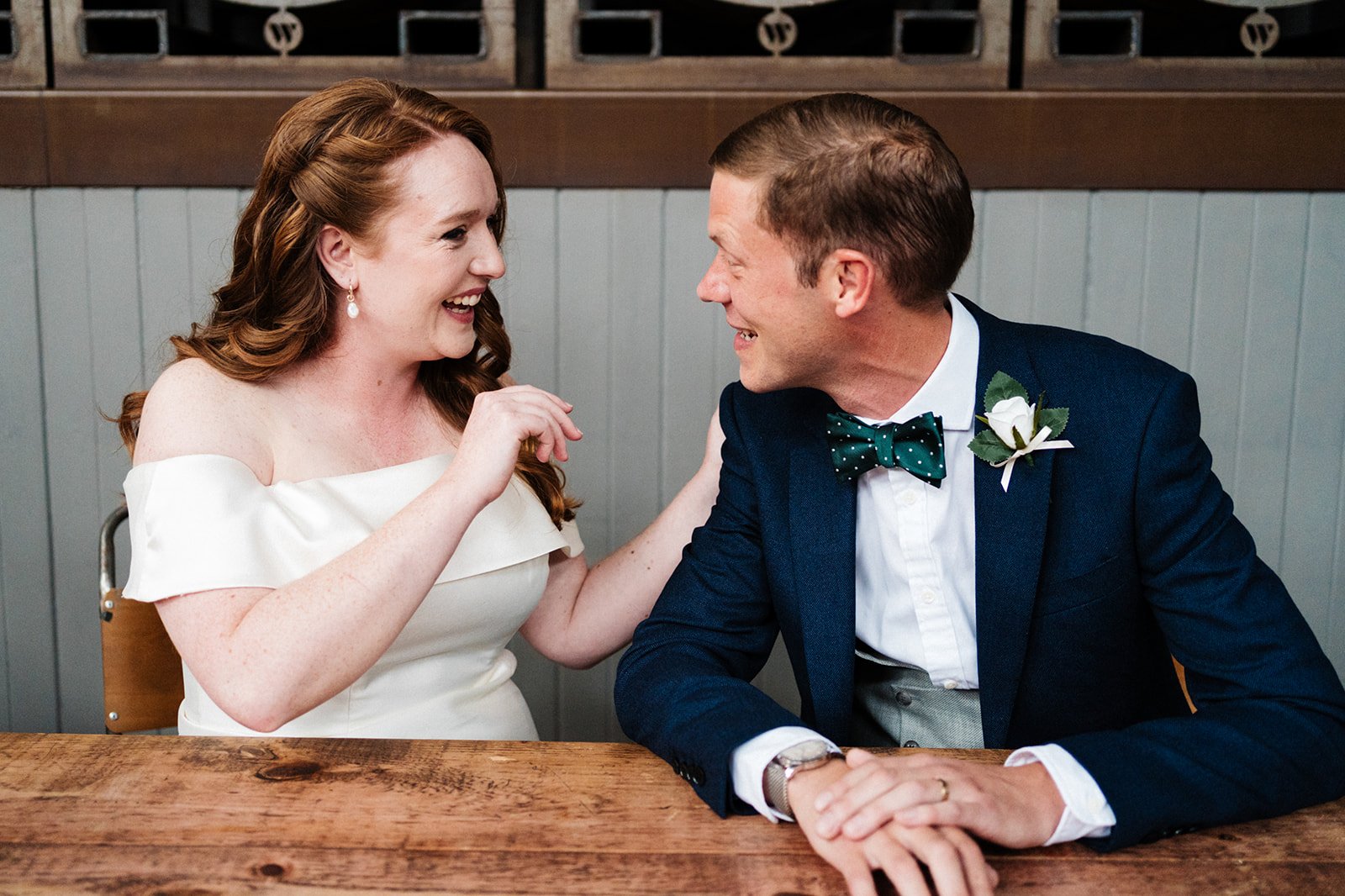 Bride and groom look excitedly at each other just after signing the wedding register at Wylam Brewery in Newcastle