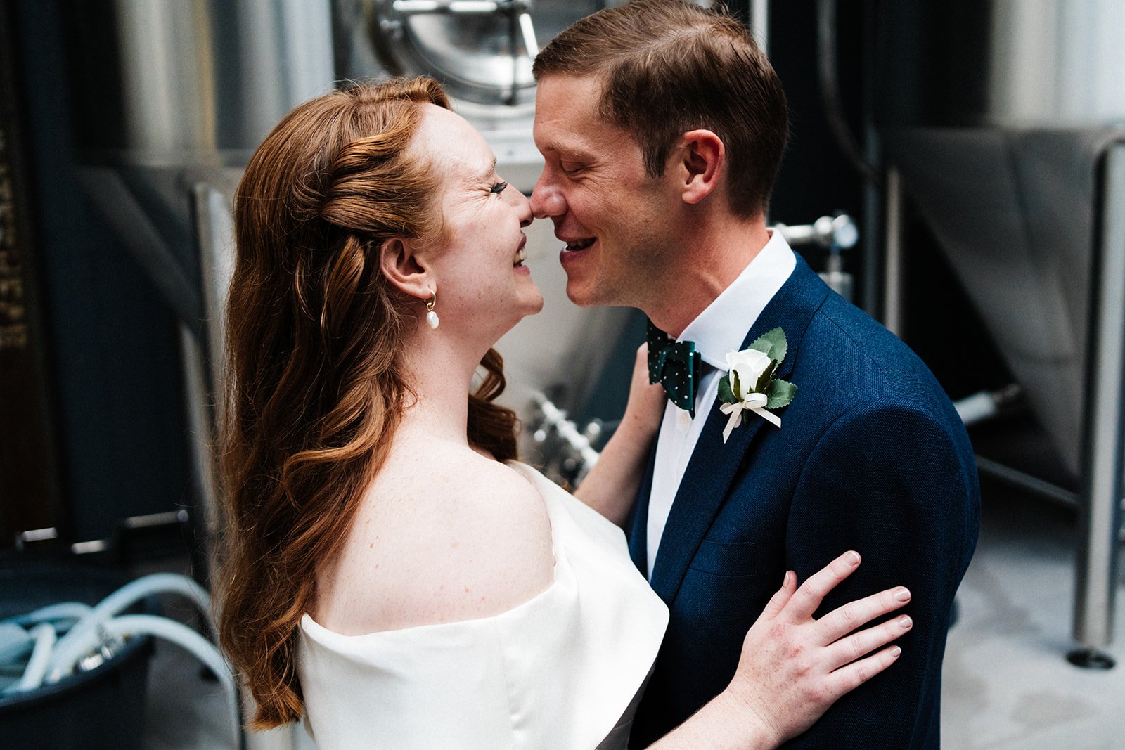 A bride and groom our nose to nose in a brewery they are smiling at each other. Wylam Brewery wedding