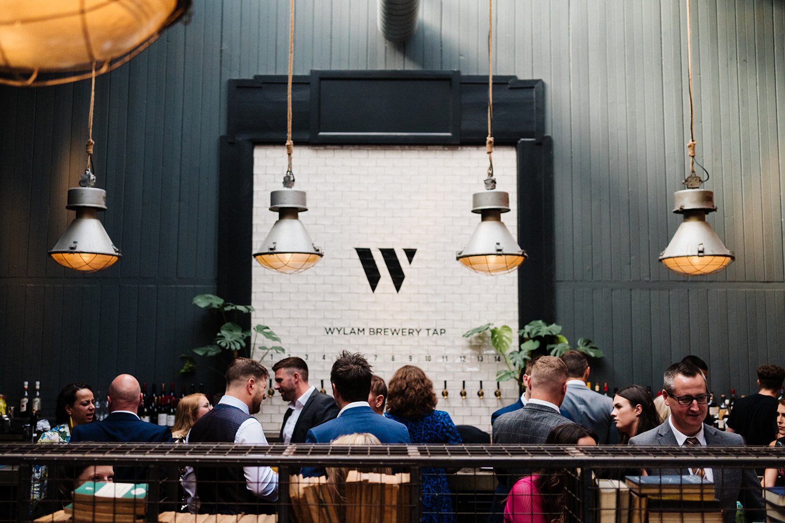 A wide shot of guests outside and industrial bar at Wylan Brewery in Newcastle