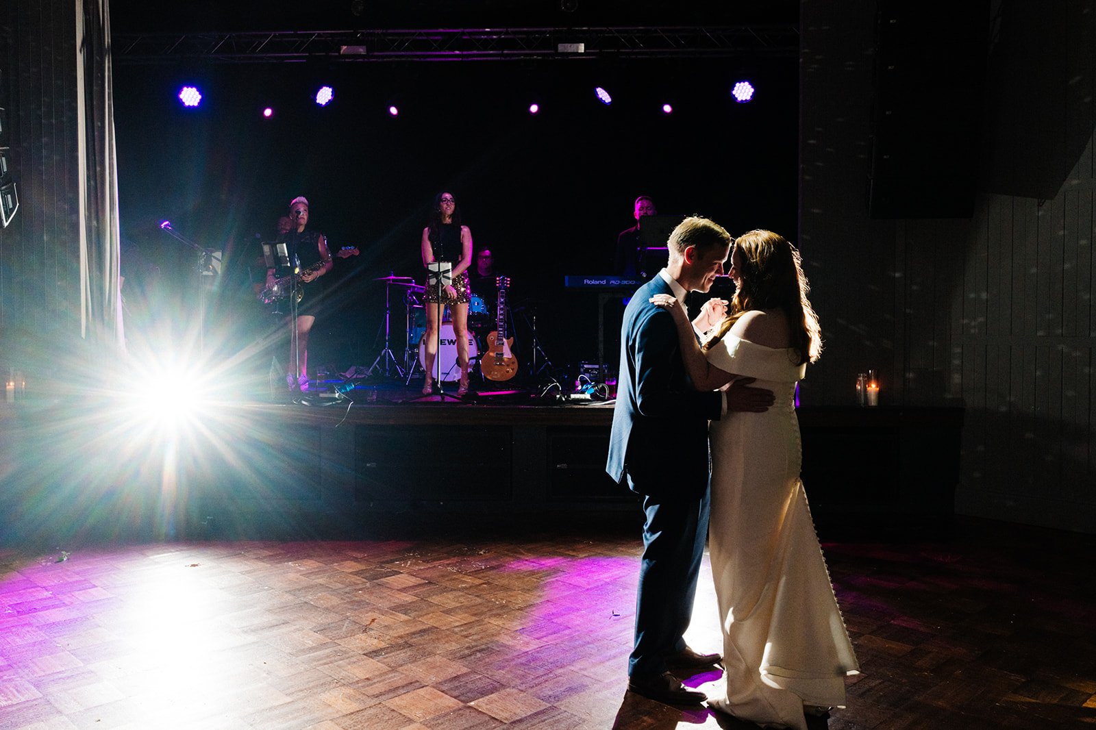 A bride and groom are under a spotlight during their first dance at Wylan Brewery in Newcastle