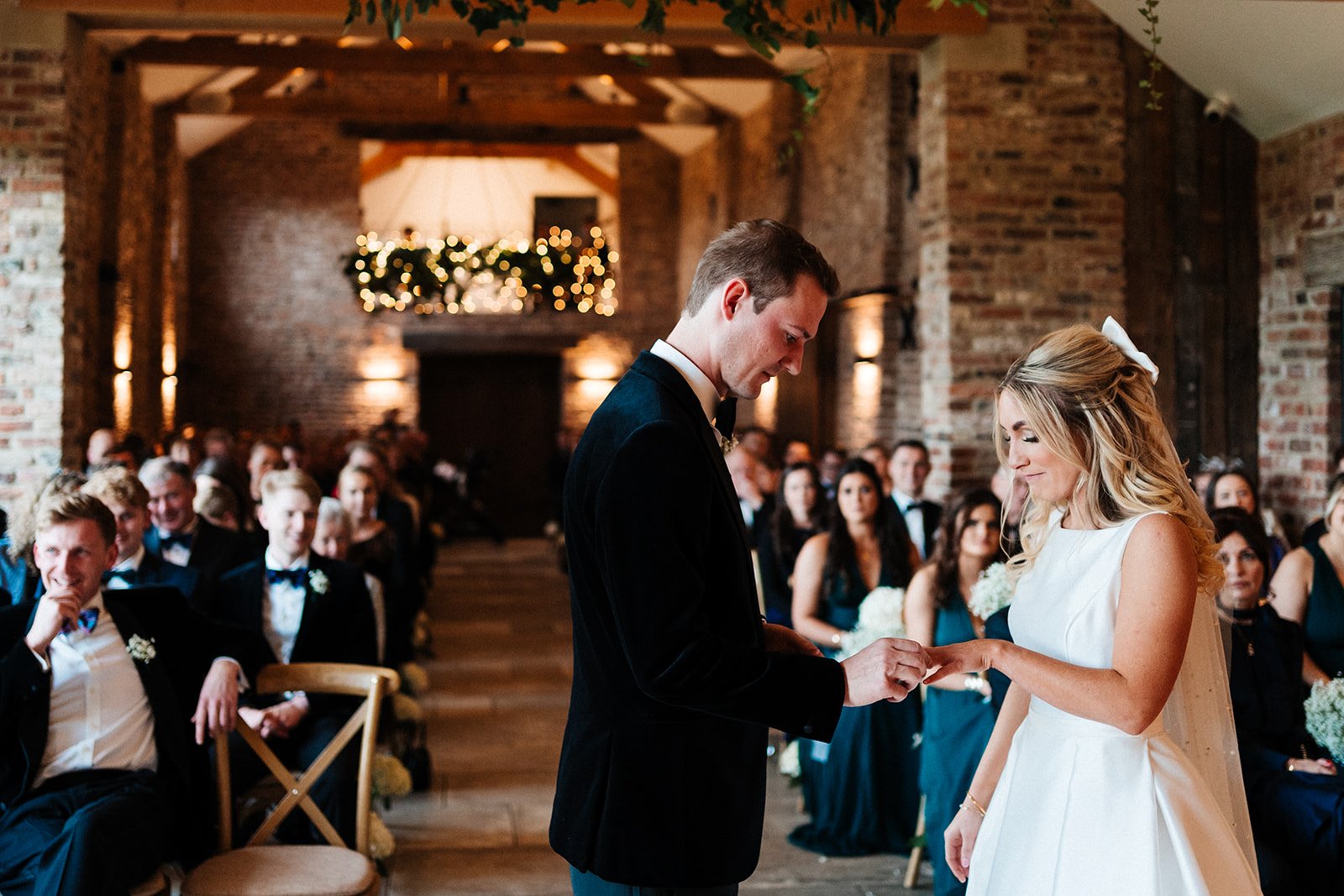 The bride and groom exchange rings in a barn ceremony room at Thirsk Lodge wedding barns