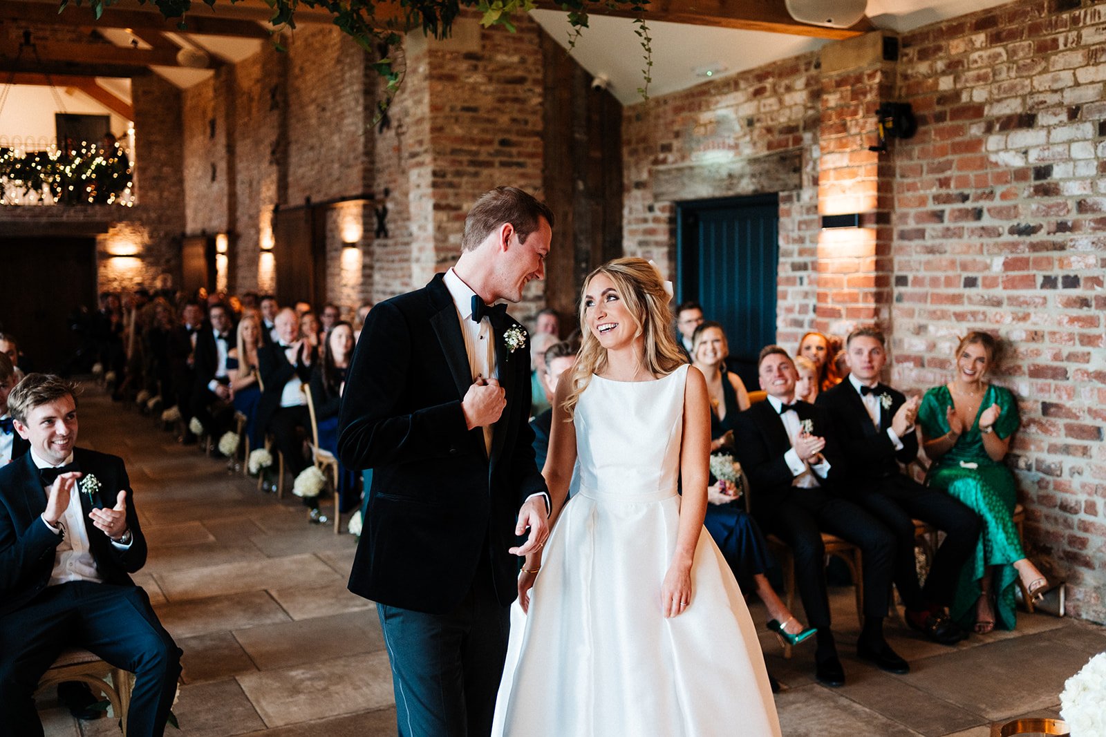 A bride and groom look at each other and smile during the barn wedding ceremony in North Yorkshire