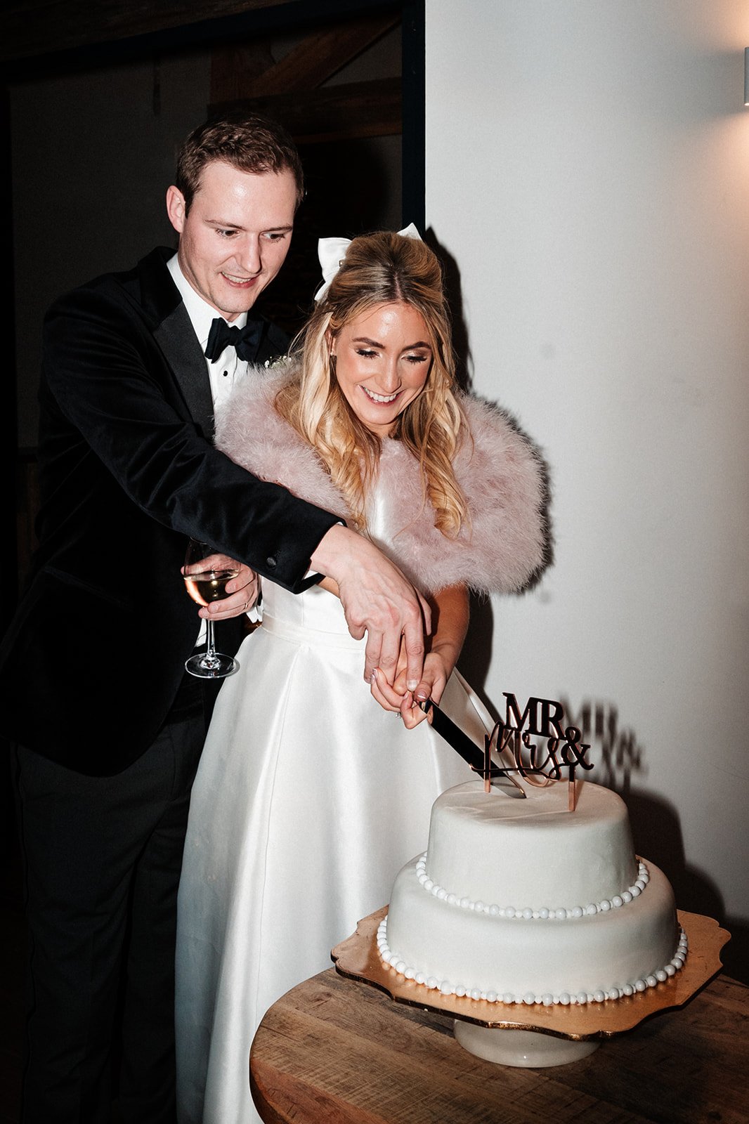 The bride and groom cut their two tier wedding cake with a large knife