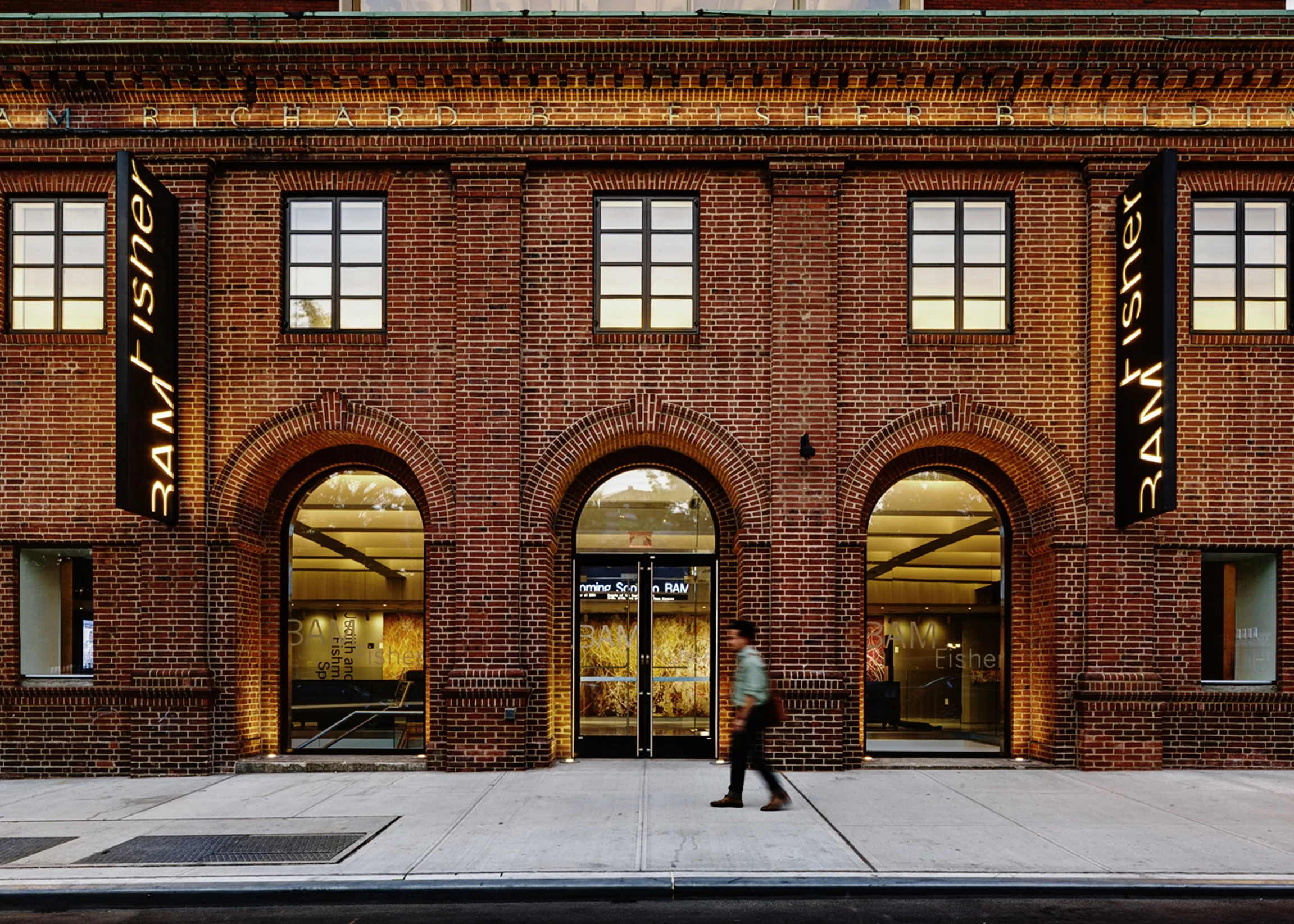 PROJECT: Brooklyn Academy of Music, Richard B. Fisher Building LOCATION: Brooklyn, New York CLIENT: Brooklyn Academy of Music COMPLETION: 2012 SIZE: 38,000 Square Feet COST: $26 Million To create the new Richard B. Fisher Building, H3 worked with the Brooklyn Academy of Music to transform a historic 1928 building into a new home for emerging artists and community groups, innovative arts education programs, and intimate performances. The renovation of the two-story historic building and the six-story addition reflect the project’s location in the BAM Historic District. The addition’s façade provides a subtle, textural counterpoint that lets the historic Salvation Army building take center stage. During the day, the building provides continuity with the adjacent historic façades of the BAM Opera and Williamsburg Savings Bank Tower; at night, it glows as a beacon on the block, with light and activity. The project adds the 250-seat Fishman Space and the 100-seat Hillman Studio to the portfolio of venues at BAM, providing much needed smaller size spaces to accommodate experimental, international, and community events and rehearsals. The compact design also integrates a flexible two-level lobby space with bar/concession stand, classroom, offices, support spaces, and a landscaped roof terrace. The Fishman space is BAM’s first fully-flexible, fully-adaptable theater. Telescoping seats and railings are moveable and removable. A ceiling tension grid allows adjustment of all lighting, sound, and ventilation positions, providing endless possibilities for reinvention.With LED lighting, an extensive green roof, solar shading, and efficient mechanical systems, the project earned a LEED-NC Gold rating.