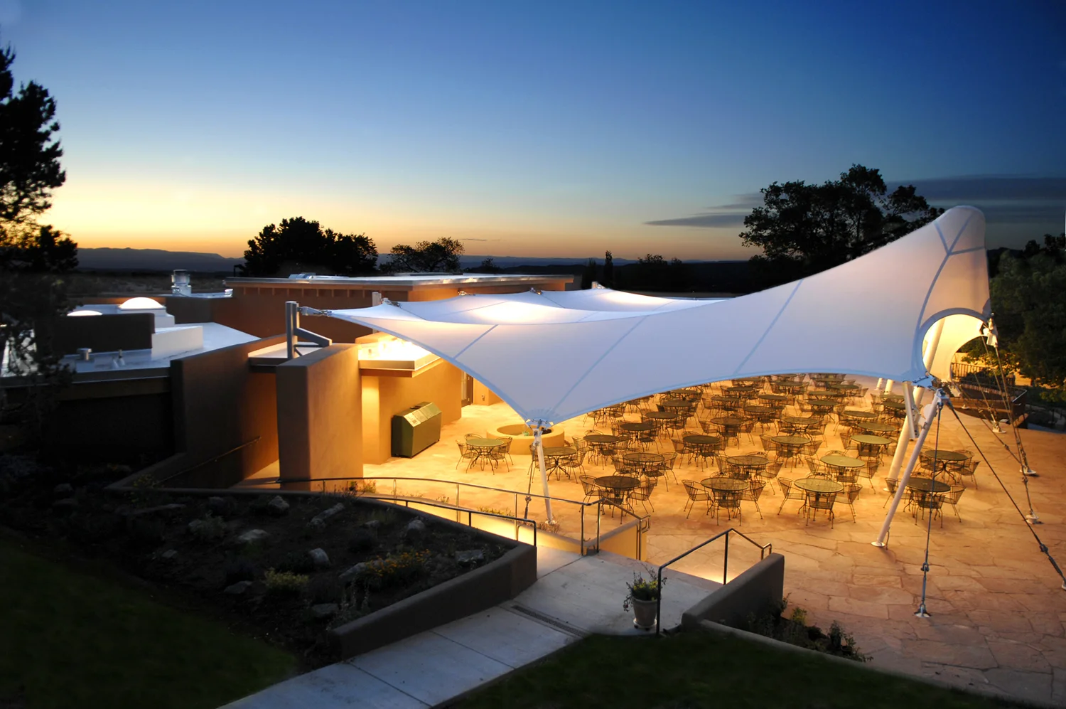 PROJECT: Santa Fe Opera the Ranch, A Long Range Plan LOCATION: Santa Fe, New Mexico CLIENT: Santa Fe Opera COMPLETION: Vocal Studio (2007), Cantina (2006), Two Rehearsal Halls (2011), Two Vocal Studios and Three Coaching Studios (2013) SIZE: 10-Acre Campus COST: Withheld at Client’s Request The Santa Fe Opera is renowned for its summer opera festival. H3 is implementing a master plan for “the Ranch,” the Opera’s ten-acre rehearsal and administrative campus. Home to a core staff of 75, which grows to 600 during the summer months, the Ranch is an active place throughout the festival season. Sounds of private vocal coaching and opera rehearsals can be heard wafting from various buildings. The acoustic mingling that results adds to the campus environment and reinforces its informal character. H3’s plan proposes a long-range strategy for facilities that meet the Ranch’s growing needs and maintain its intimate character. The plan’s purpose is to improve facilities for the company, staff, and artists and to upgrade the dining facilities so that receptions can be held. These needs will be met in five phases, implemented in order of priority. Each includes the addition of a major new building and commensurate landscape improvements. The plan takes maximum advantage of existing elements and strengthens linkages among the Ranch’s various areas. The measurable progress in each phase will demonstrate tangible improvement, which in turn will assist in fund-raising. The completed Ranch will be a source of pride for generations to come.