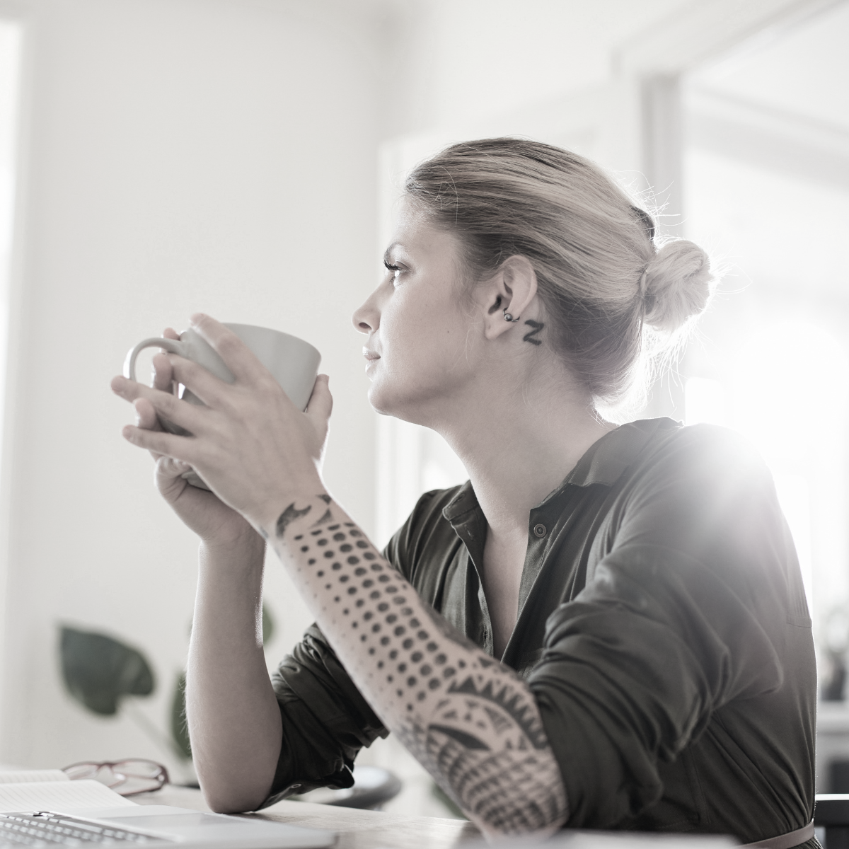 Woman in her 30s looking out a window, reflecting on fertility and egg freezing decisions
