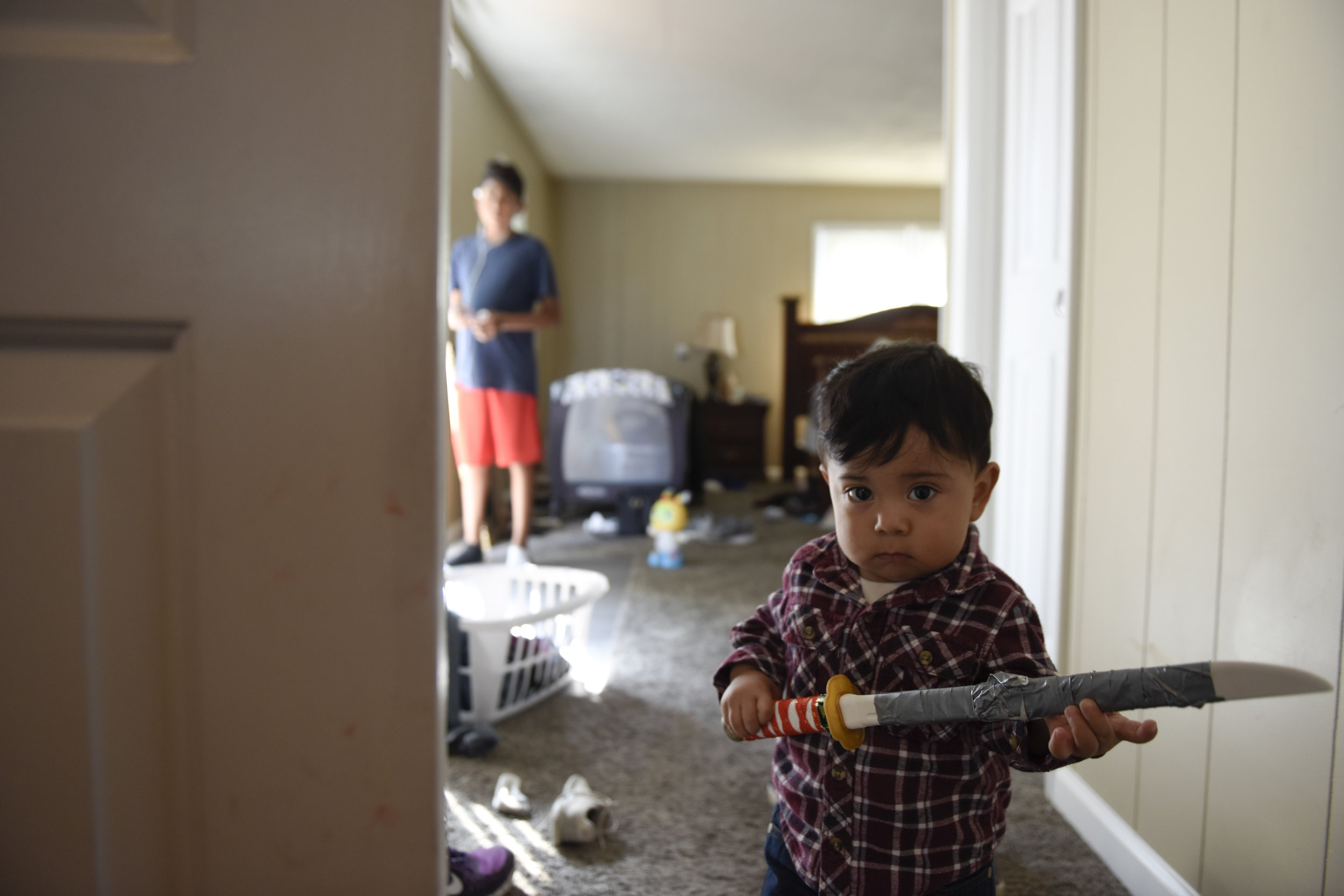 One-year-old Xavi Herrera-Garcia plays with a taped up ninja sword as his uncle Kevin Garcia, 13, watches him on Saturday, Sept. 23, 2017. Both are U.S.-born citizens, but Garcia spent most of grade-school years in Mexico after moving with his