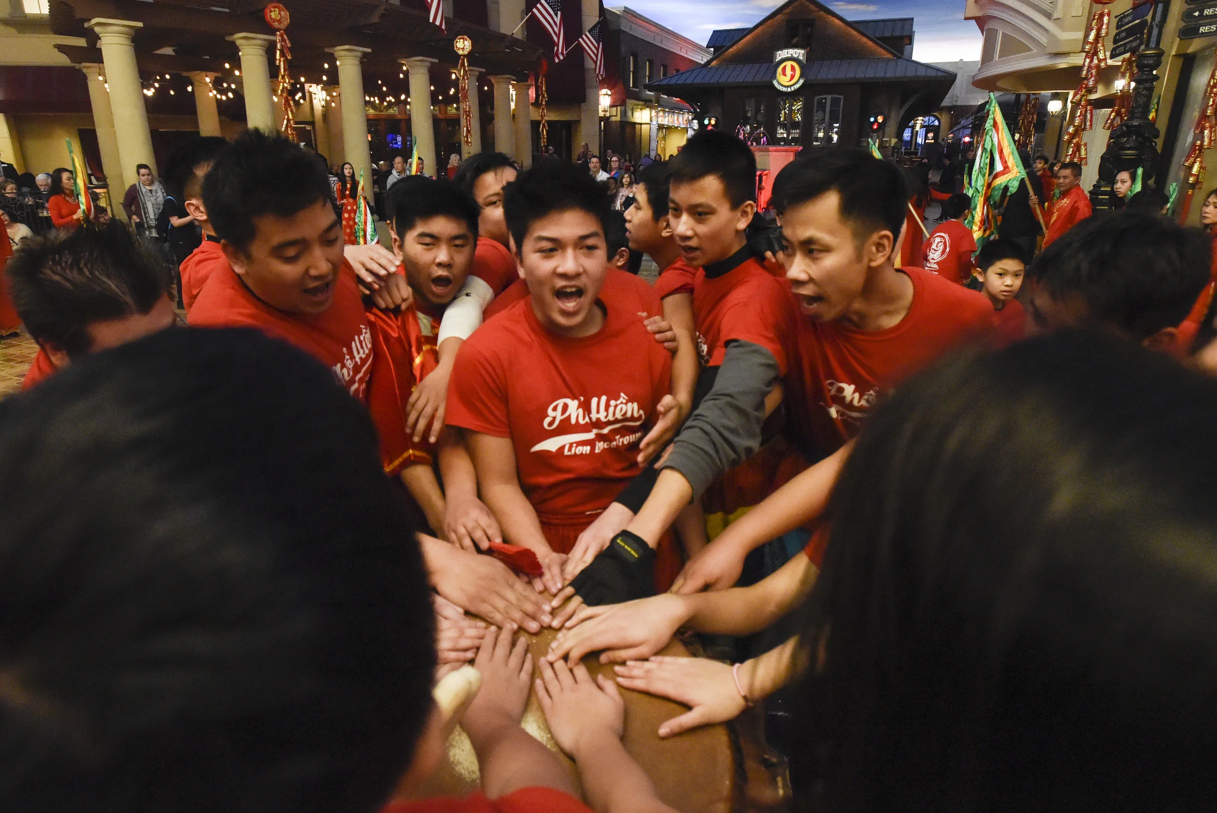  Leader Daniel Van, gray-sleeved on right, places his hand on the drum as the entire team chants "Lion Dance P.H." before a major performance on Saturday, Feb. 17, 2018 at Ameristar Casino in Kansas City, Missouri. Since moving to Missouri for school