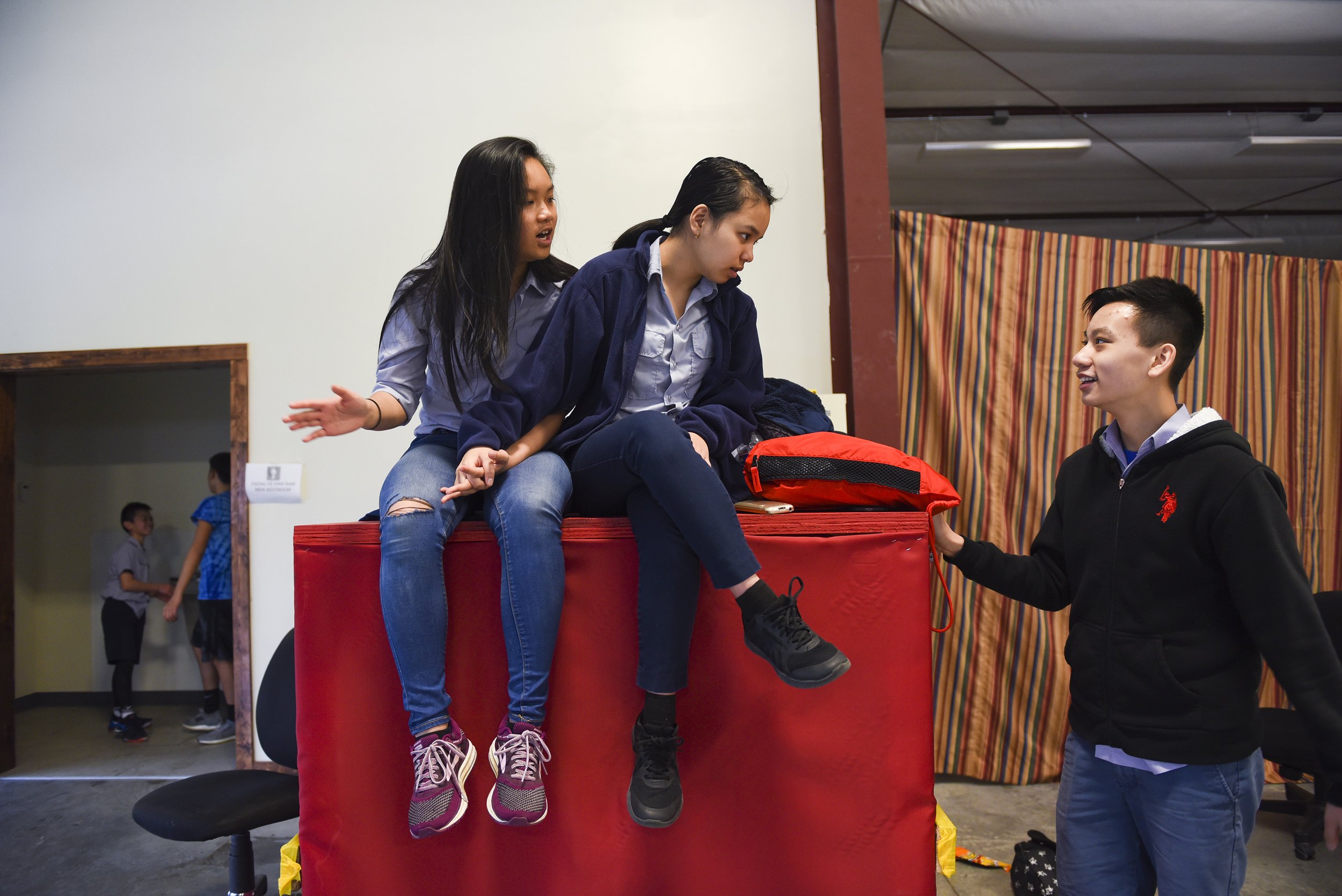Jacklynn Pham, 16, Ann Nguyen, 16, and Steven Tran, 15, talk during recess hours after lunch on April 15, 2018 at Pho Hien Buddhist Temple in Kansas City, Missouri. The members are allowed an hour of free time to play after lunch outside or in the g