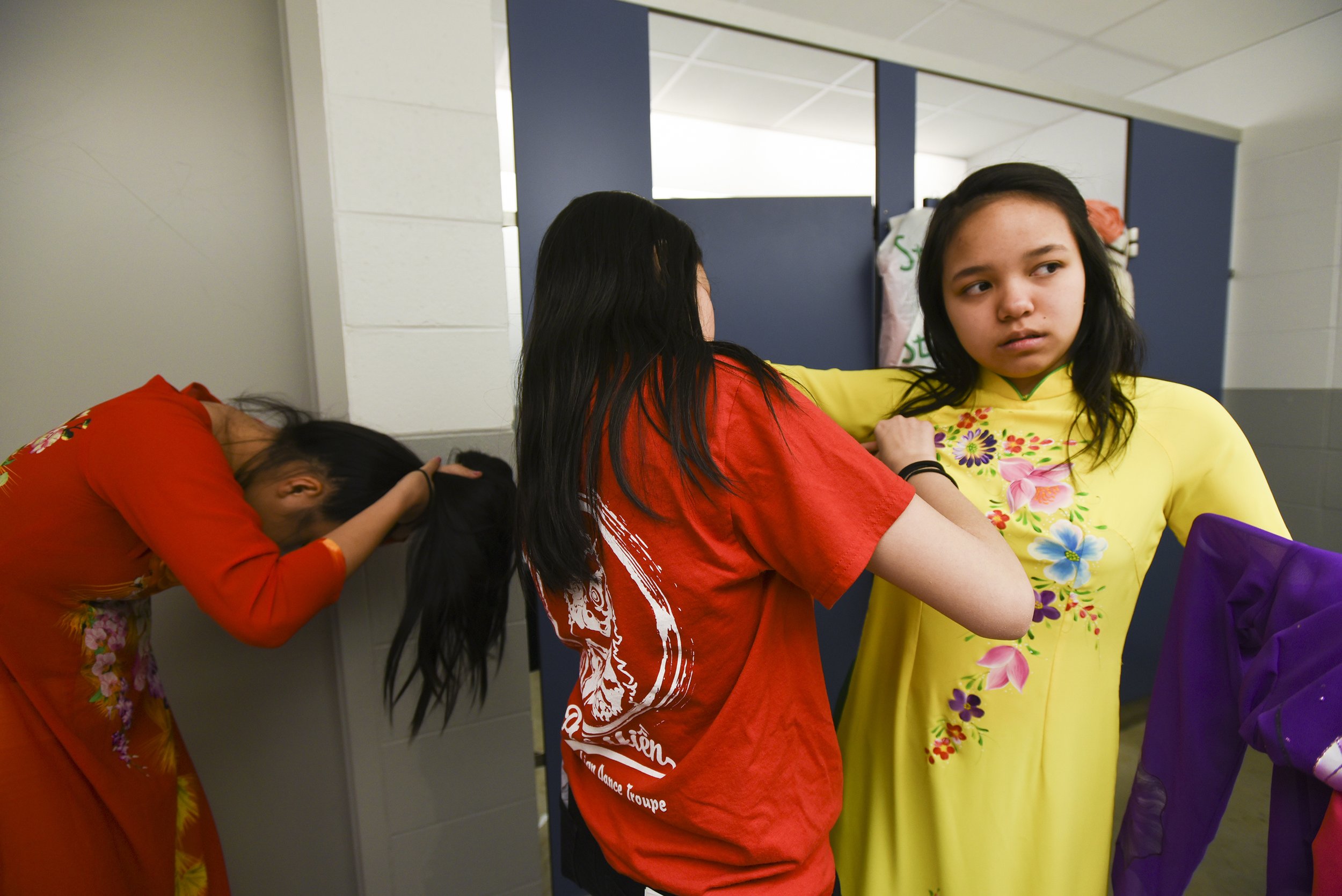 Jacklynn Pham, 16, Erica Pham, 17, and Ann Nguyen, 16, prepares for the ao dai contest on April 28, 2018 at Garrison Community Center in Kansas City, Missouri. The ao dai is a traditional Vietnamese dress that's typically long, fitted and worn by wo
