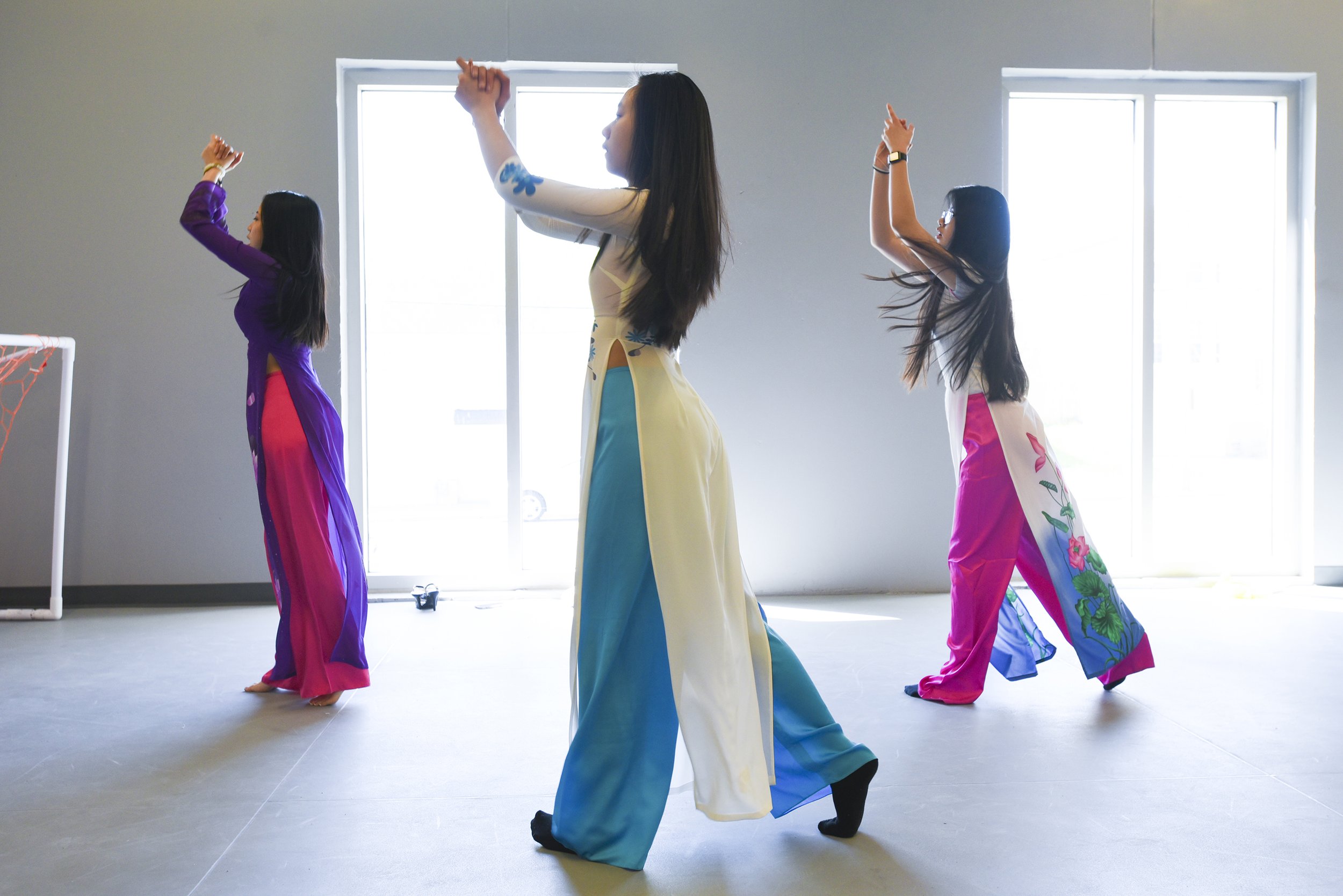 Dancers Erica Pham, 17, Jenny Tran, 14, and Charlene Nguyen, 14, practices their dance routine on April 28, 2018 at Garrison Community Center in Kansas City, Missouri. The dance showcased traditional Vietnamese dresses and colorful fans.