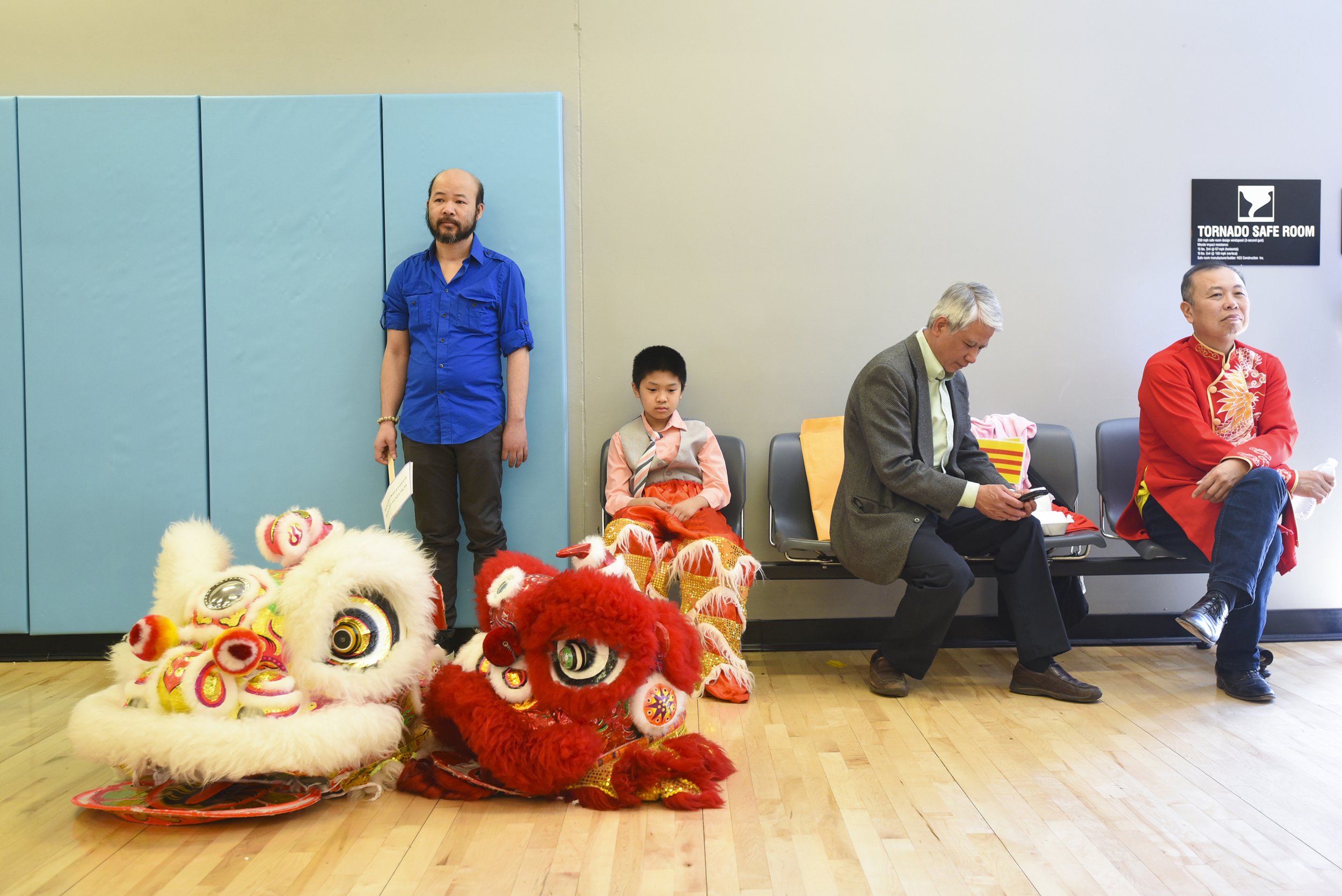 Ten-year-old Lance Le, red lion dance pants, waits to perform on April 28, 2018 at Garrison Community Center in Kansas City, Missouri. Le and his older brother Loc Le are paired as head and tail during lion dancing.