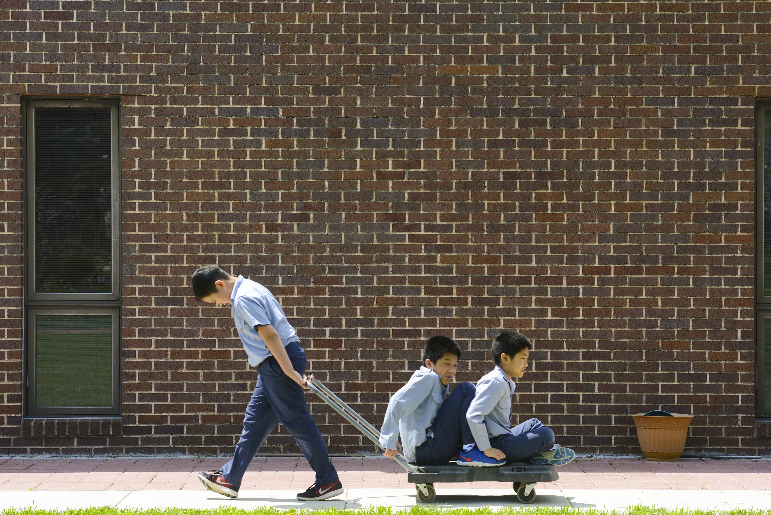 Ryan Tran, 9, pulls brothers Loc, 12, and Lance, 10, Le, on a trolley around Pho Hien Buddhist Temple in Kansas City, Missouri. All three boys are a part of the Oanh Vu Nam group in Gia Dinh Phat Tu Pho Hien. Oanh Vu Nam is for boys aged six to 12.
