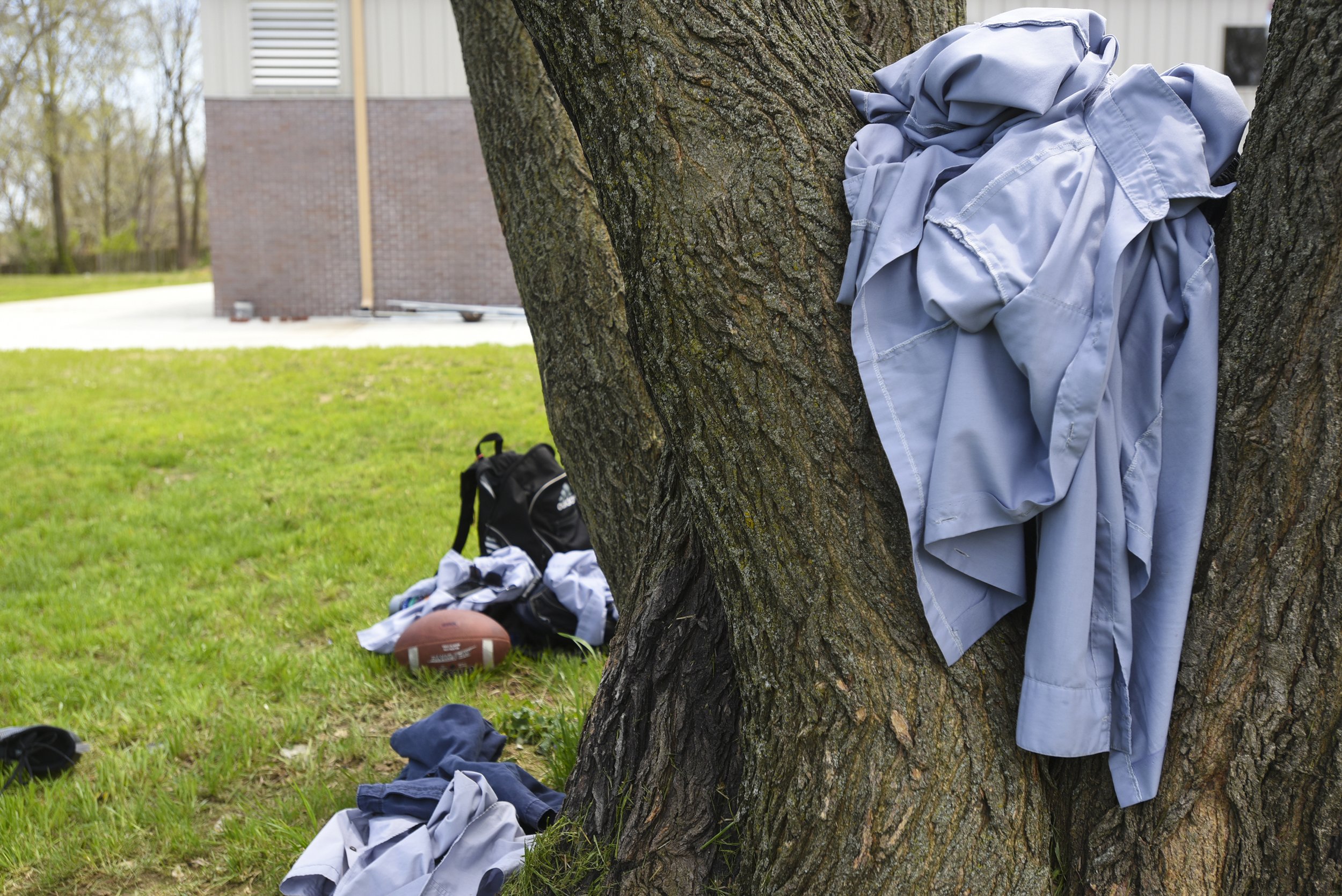 A bundle of ao lam, or gray shirts, sit in a tree on April 29, 2018 outside Pho Hien Buddhist Temple in Kansas City, Missouri. The ao lam is a part of the traditional buddhist youth association's uniform. It symbolizes unity, harmony, patience, dili