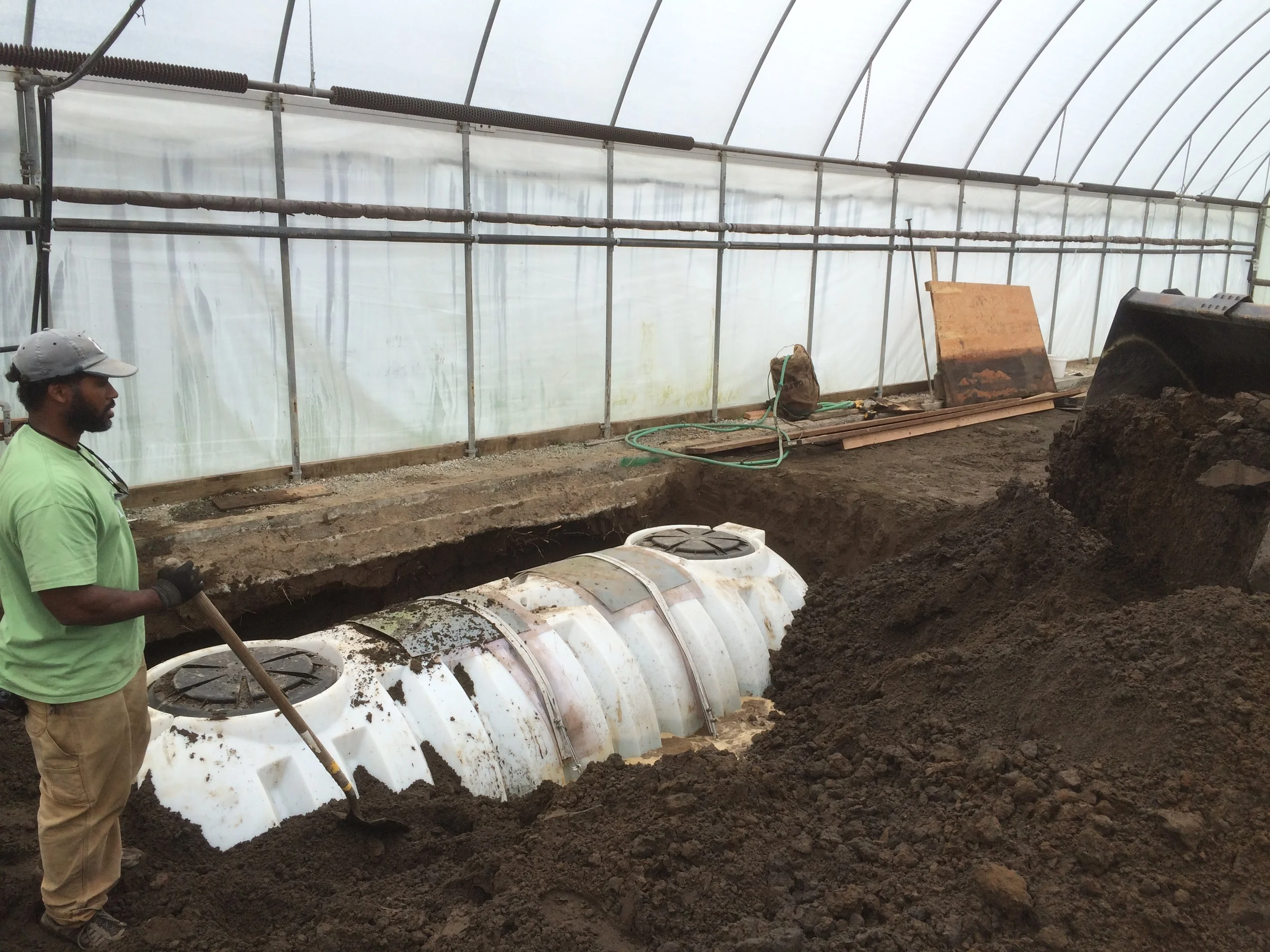 Jason is putting the finish grade on the tank after we too the water out. It will finish to the two entrances you can see on the top. This is where our main pump etc will go. Along with all the water drains!