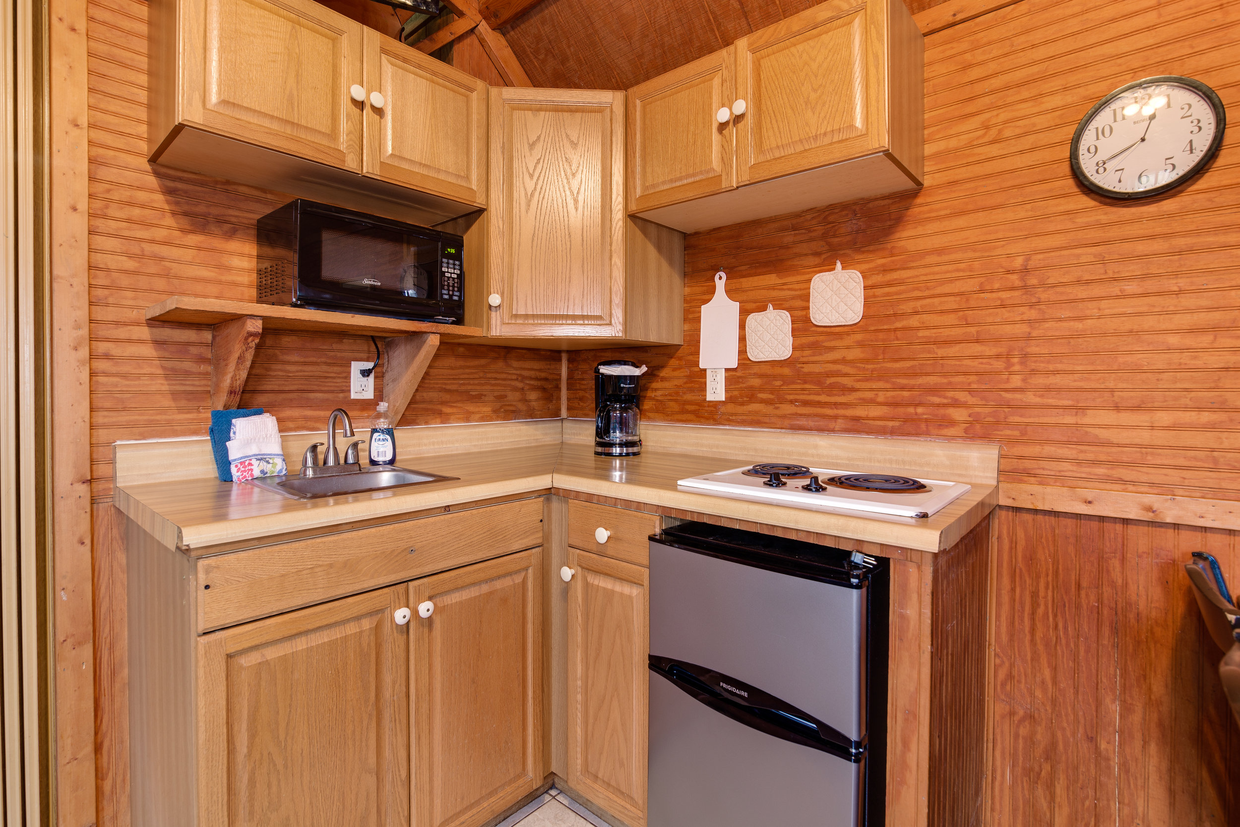  The partial kitchen, featured here, includes a small refrigerator, two burner cooktop, microwave, sink, toaster, and coffee maker. Dishes, flatware, pots and pans, and glassware are also included. 