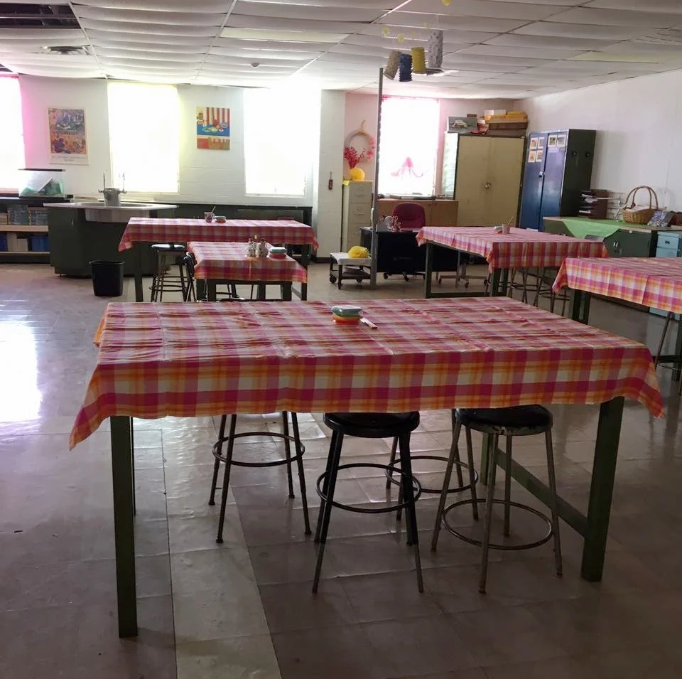 By early October, Ms. Ravalier had completed the entry to her classroom “Science Café,” complete with artwork on the door and cheerful tablecloths – though ceiling tiles still displayed evidence of Hurricanes Irma and Maria. Photo by Michealrose Ravalier.
