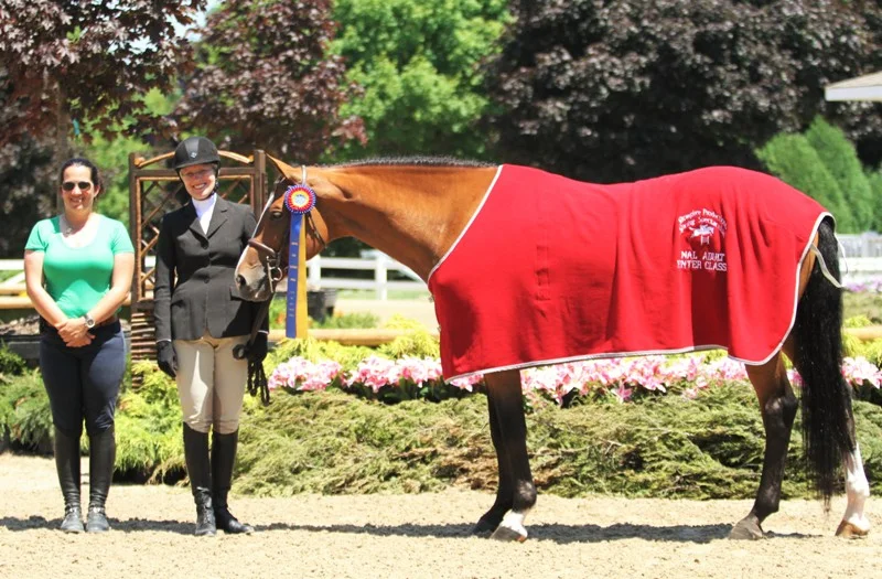 The class sponsor poses with Naples Bay and Debra Kirsch $1000 NAL Adult Hunter Classic $500 WIHS Adult Hunter Classic Naples Bay, owned and ridden by Debra Kirsch, had a successful morning, taking home titles in the NAL and WIHS adult hunter classics. “He’s brand new. I just got him in April from Naples, Florida, hence the name,” Kirsch said. “This is our first horse show together, so we’re off to a banner start. I’m very excited. He’s a terrific horse with a great rhythm and we’re finding good rhythm together. I have been showing in hunters basically my whole life. This is just part of who I am. Today was a great day, probably one of my best horse show days ever.”