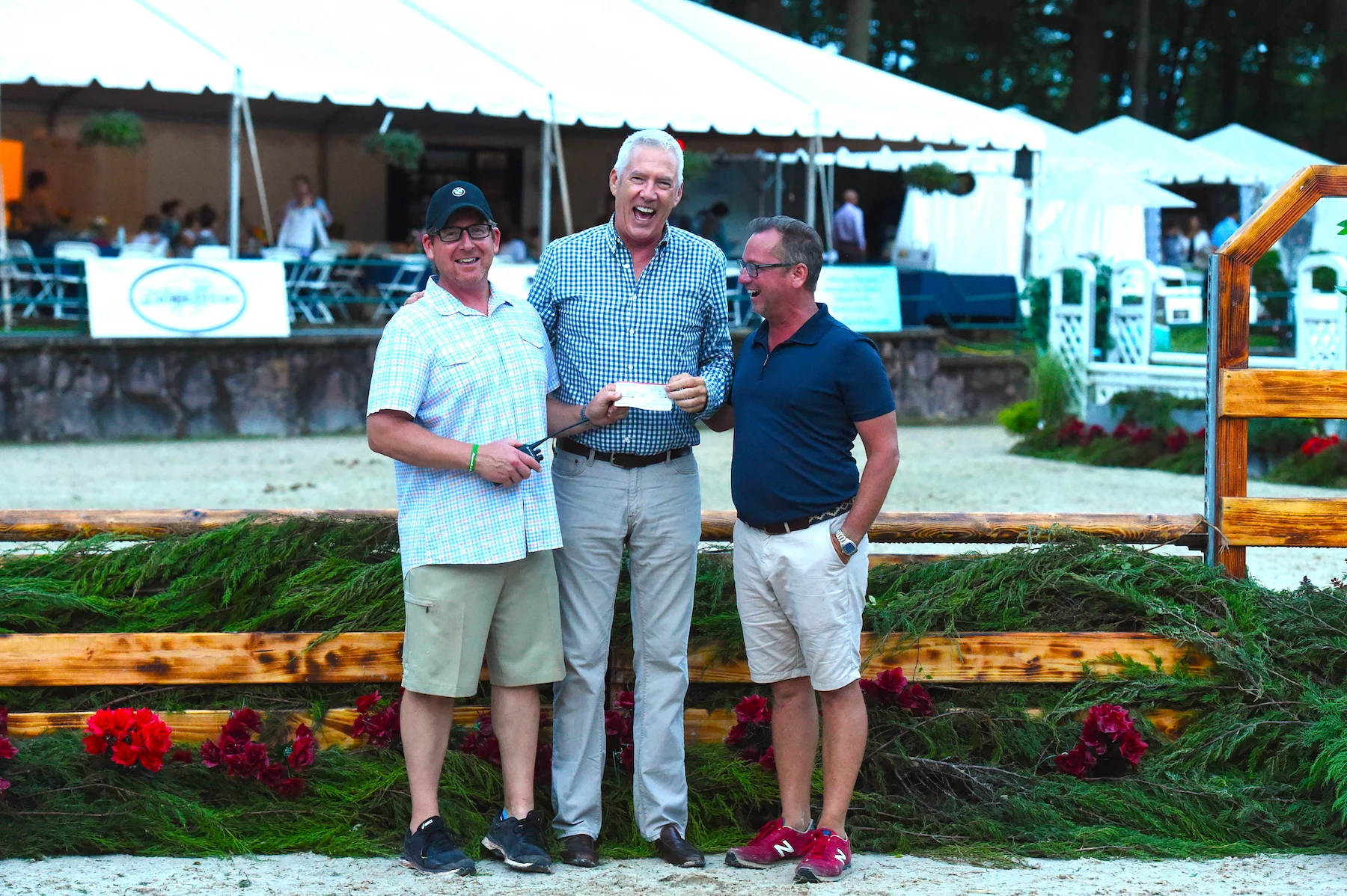 Tucker Ericson and Michael Dowling present a check on behalf of Monmouth at the Team to the Equestrian Aid Foundation board member Scot Evans.Photo by Anne Gittins Photography
