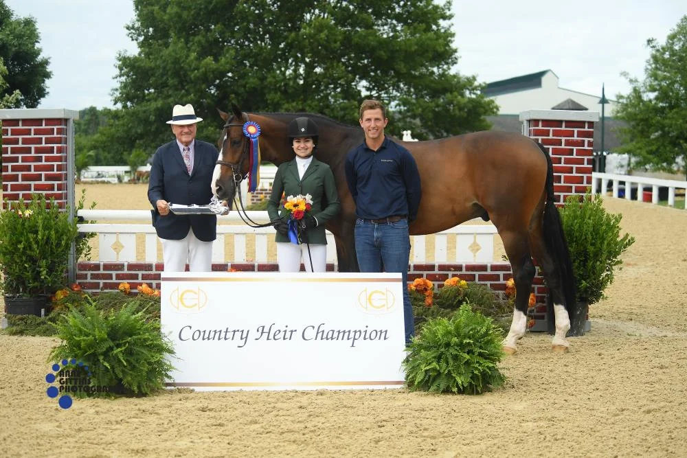 John Franzreb presents the championship of the 3'3" Junior Hunters 15 and Under to Mia Chimenti and Ericsson with trainer Michael Meyers. Photo by Anne Gittins Photography