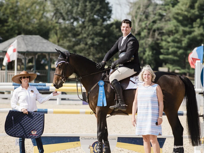 Cynthia Hampton from Classic Champions presents the award to David O'Brien aboard Maldonado SCF and Lisa Lourie from Spy Coast Farm for their win in the 7-Year-Old Jumpers. Photo by EQ Media