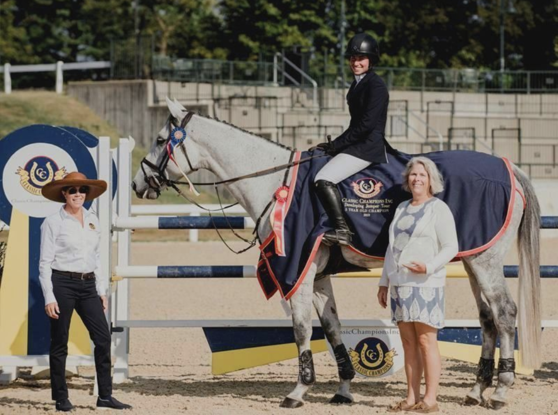 Cynthia Hampton presenting the championship ribbon and Classic Champions Award of Distinction to Out Of The Blue SCF (Verdi x Casa Blanca La Silla), owned and bred by Lisa Lourie and Spy Coast Farm and ridden by Jennifer Waxman, for the 5-year-old division during the Finals at the Kentucky National Horse Show. Photo By EQ Media