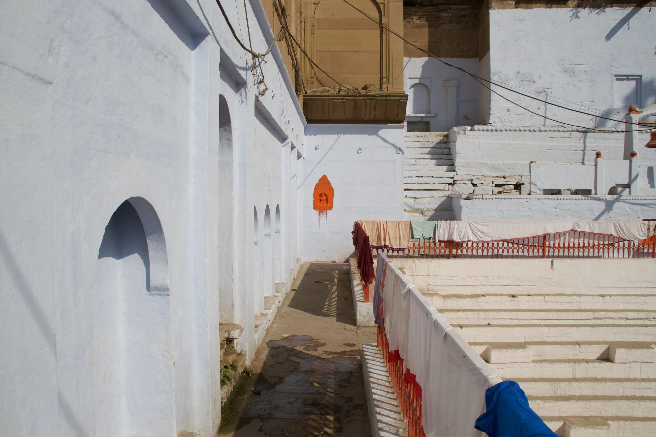 Small vermilion shrine agains the palest blue walls, Manikarnika Kund