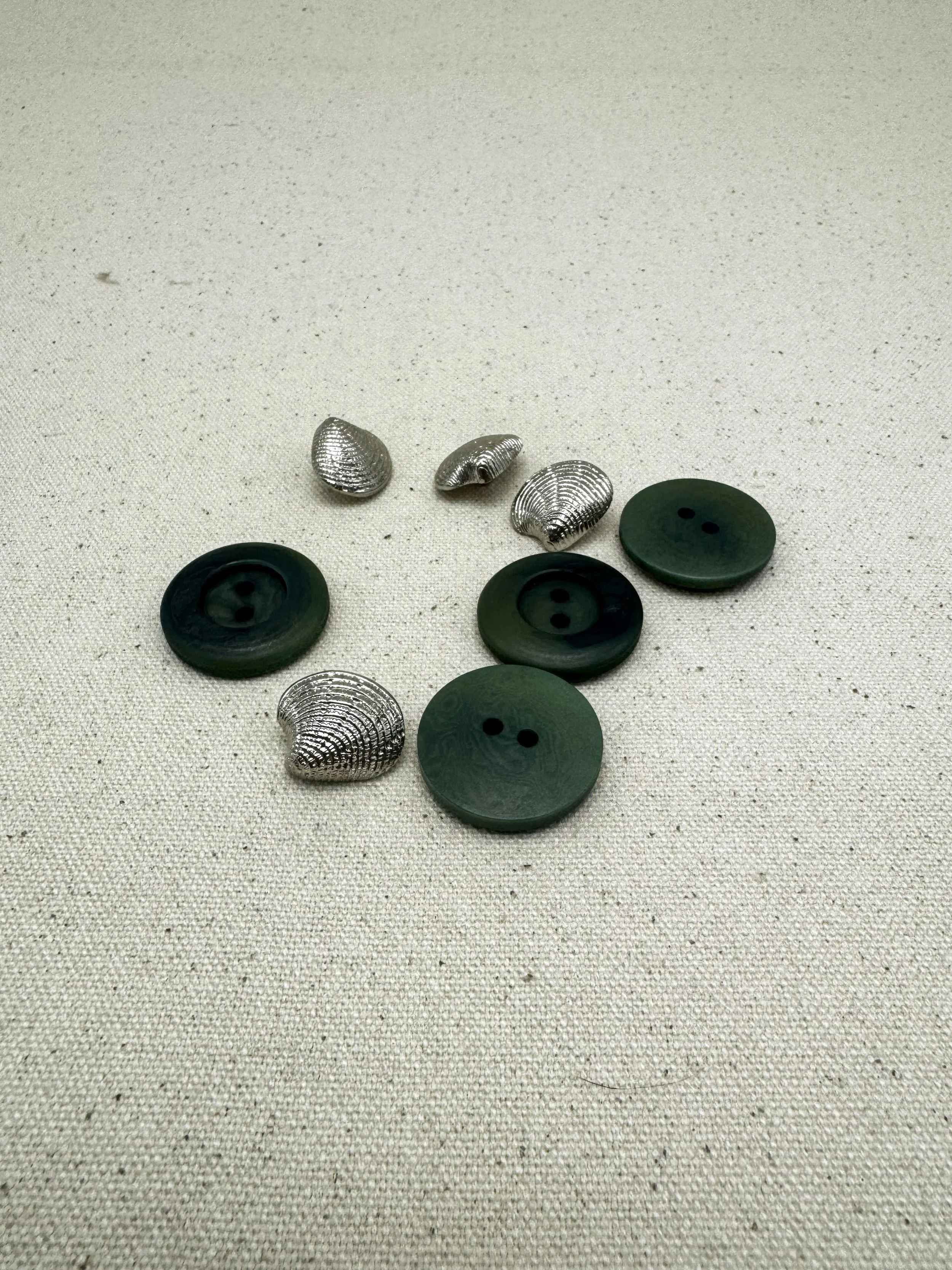 Fake pounamu buttons with fake silver cockle shell buttons (after Joe)