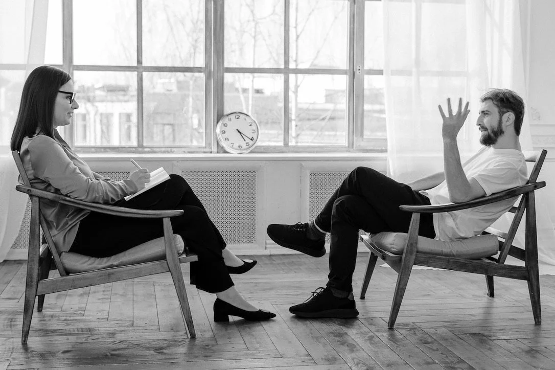 Image of a 1-on-1 counseling session with a female counselor siting across from an anonymous patient.