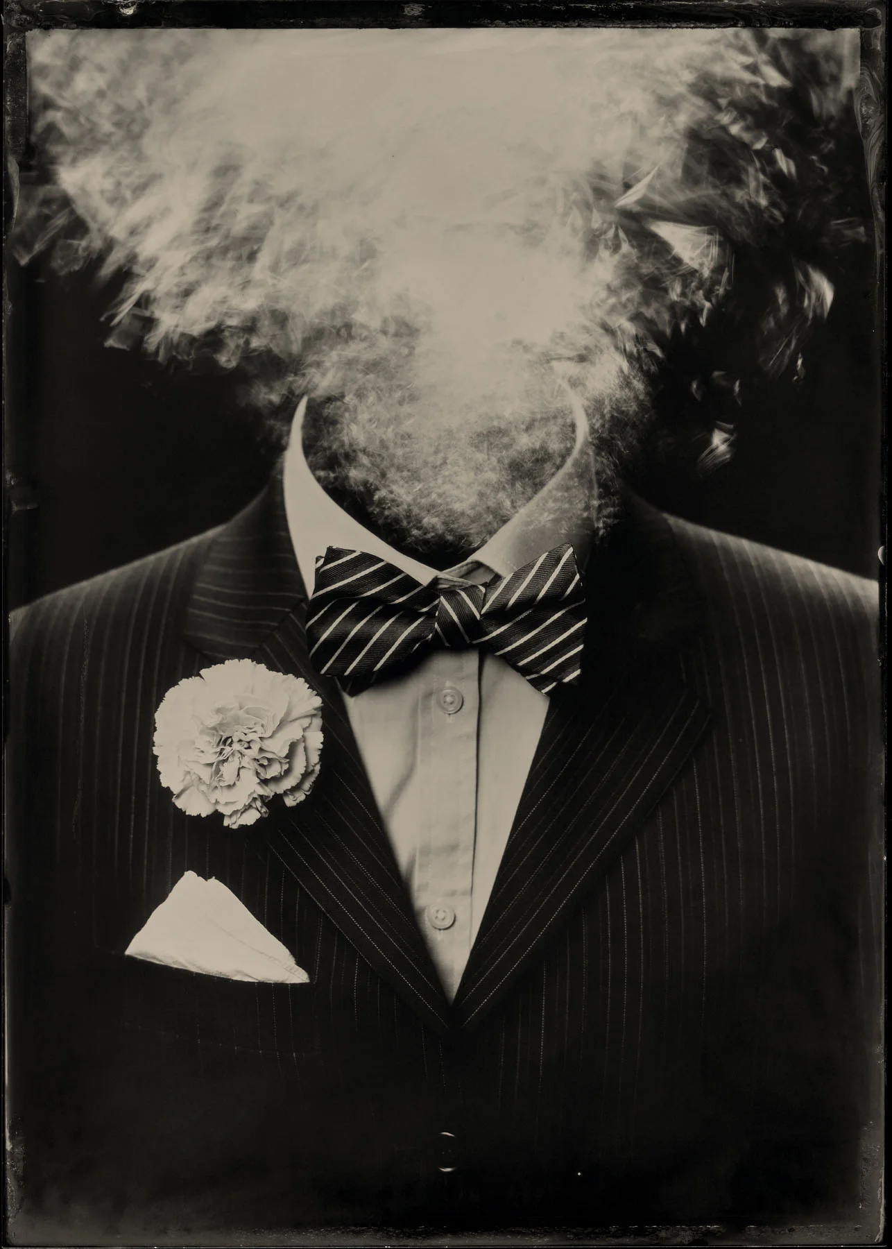 Incroyable! - By: Libby & Stephen of Henrietta's Eye www.seattletintype.com Stephen Robinson and Libby Bulloff are Seattle WA artists, working together as Henrietta’s Eye. We are primarily self-taught having been introduced to wet plate collodion almost by accident when a friend showed us the basics of the process. Admittedly, there’s more than a little bit of punk rock, DIY attitude in us, so making photographs the hard way somehow naturally meant for us that we’d also learn the hard way. About our piece, fully titled Incroyable! (Wednesday, November 9, 2016) : intentionally referencing the surrealist painter Magritte, it's our attempt at expressing the collective spasm of disbelief felt by many following the 2016 presidential election in the United States — not just the surreal nature of that moment but the outrageous nature of life since. Beyond the symbology of the carnation, the suit and tie and mushroom cloud-like explosion, it was thematically relevant to use the in-camera trick photography associated with the early 1900s spiritualist movement to express this communal gasp and the experience of being hoodwinked by charlatans. We’re extremely grateful for being recognized for our work and humbled that it was chosen from among such good company.