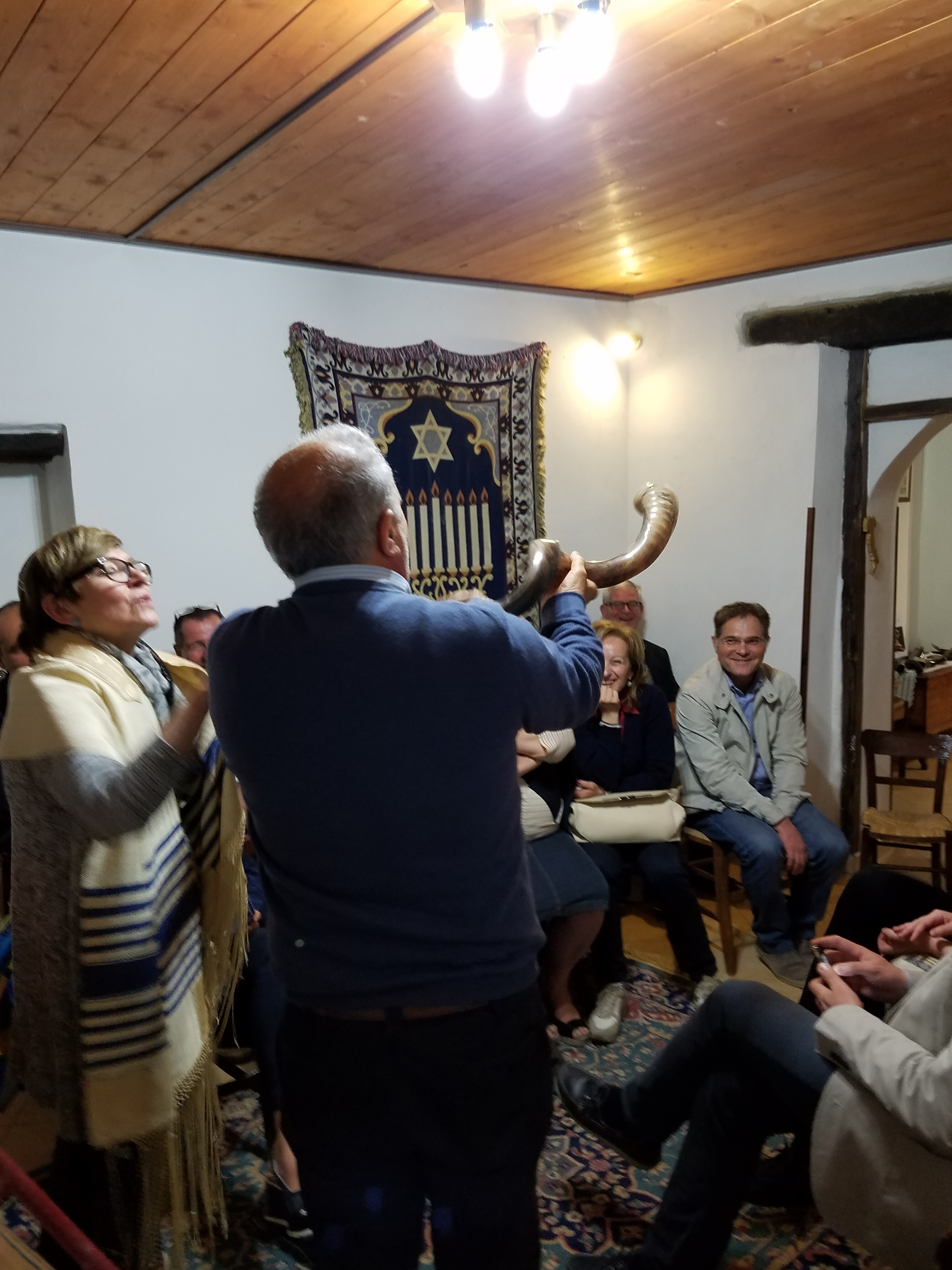 Rabbi Aiello teaching a scout leader how to blow the shofar.