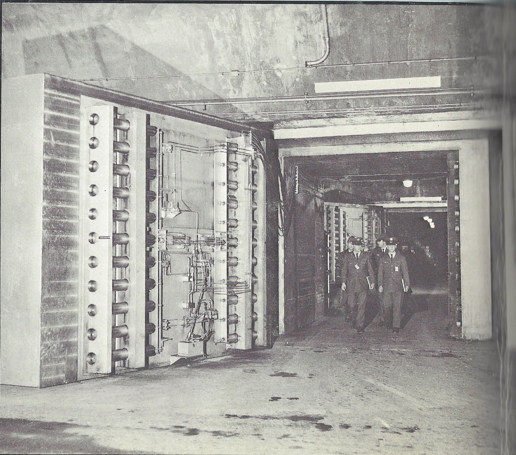  Caption: "Operations personnel coming out of the underground NORAD Command Post through one of the 25-ton doors." 