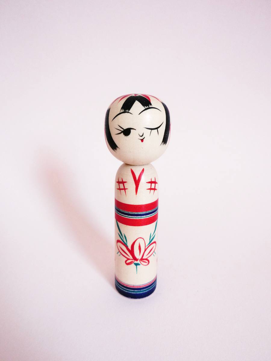 Wink kokeshi and peach flower by Kanou Hiroshi