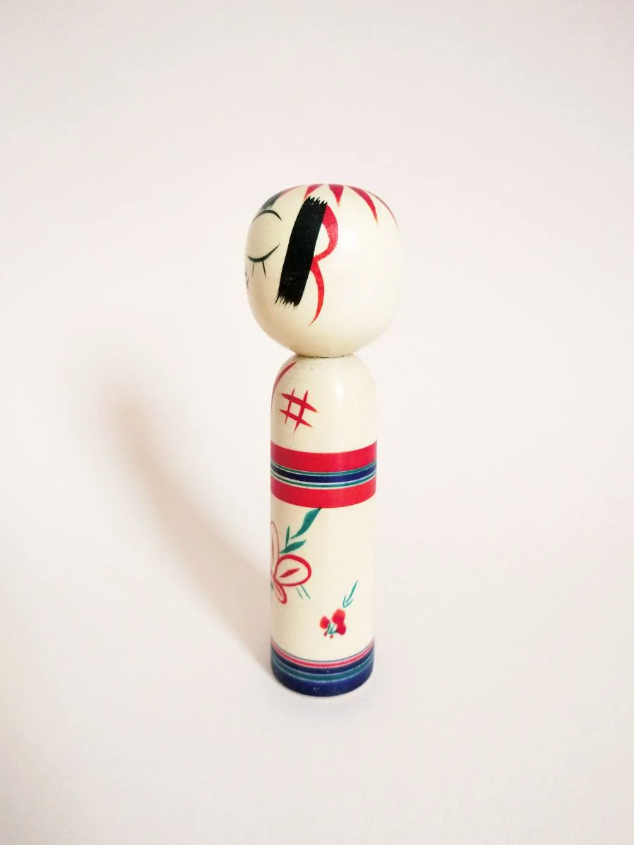 Wink kokeshi and peach flower by Kanou Hiroshi