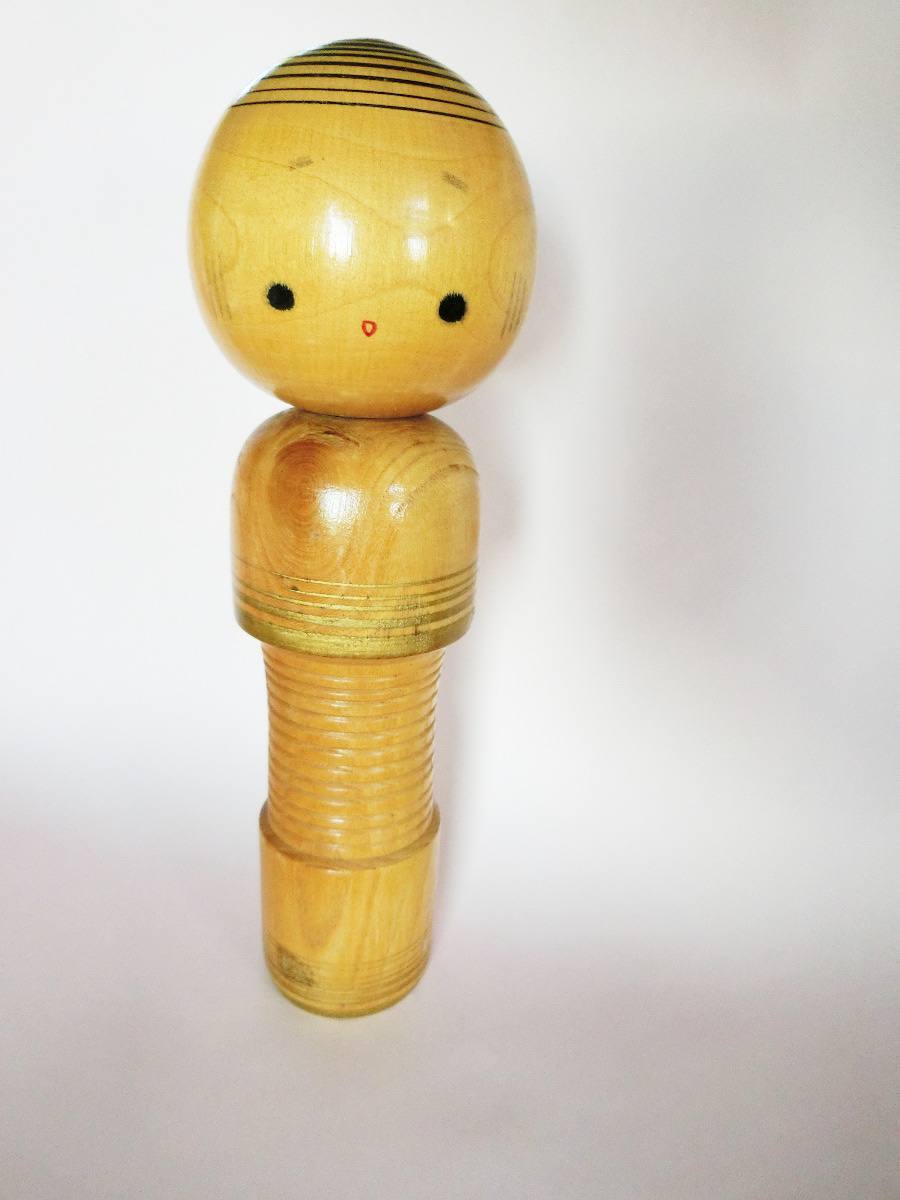 Naive style kokeshi doll with golden stripes